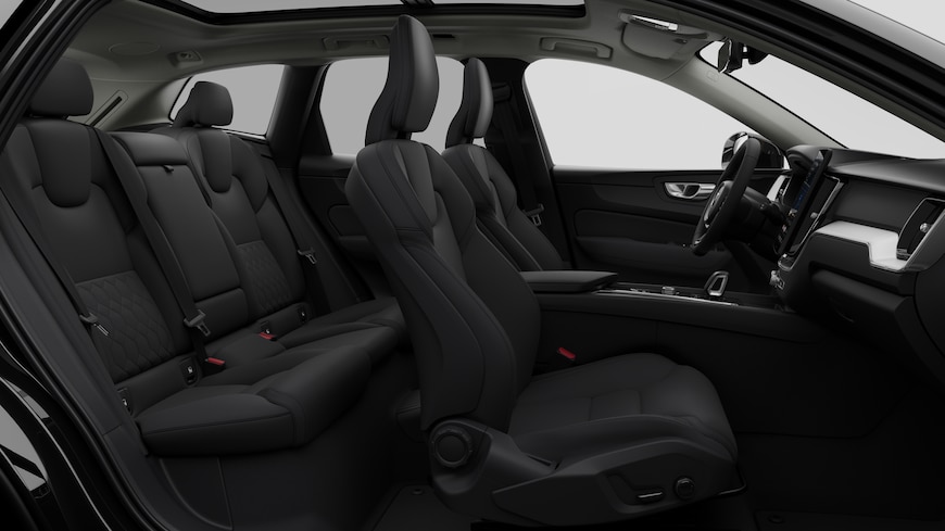 Vista lateral do interior do automóvel Volvo a mostrar os bancos dianteiros, os bancos do passageiro traseiro, o volante, o painel de instrumentos e a consola central, contra um fundo de estúdio simples.