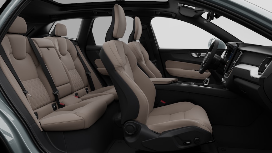 Vista lateral do interior do automóvel Volvo a mostrar os bancos dianteiros, os bancos do passageiro traseiro, o volante, o painel de instrumentos e a consola central, contra um fundo de estúdio simples.