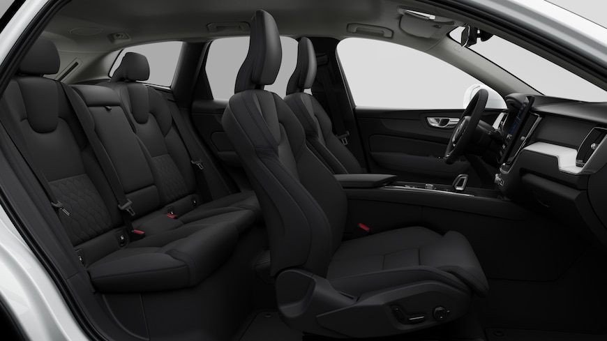 Vista lateral do interior do automóvel Volvo a mostrar os bancos dianteiros, os bancos do passageiro traseiro, o volante, o painel de instrumentos e a consola central, contra um fundo de estúdio simples.