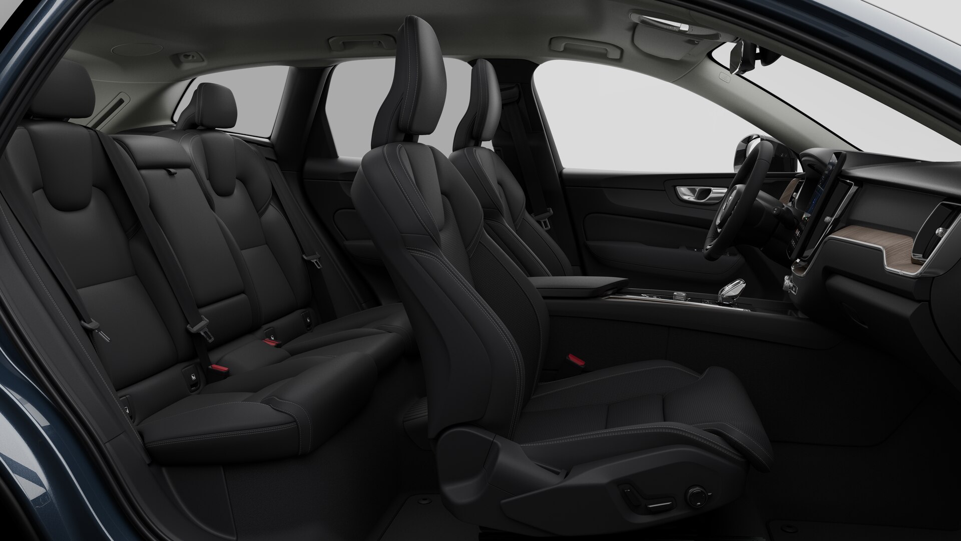 Vue latérale de l’intérieur d’une Volvo montrant les sièges avant, les sièges passager arrière, le volant, le tableau de bord et la console centrale, sur fond de studio.