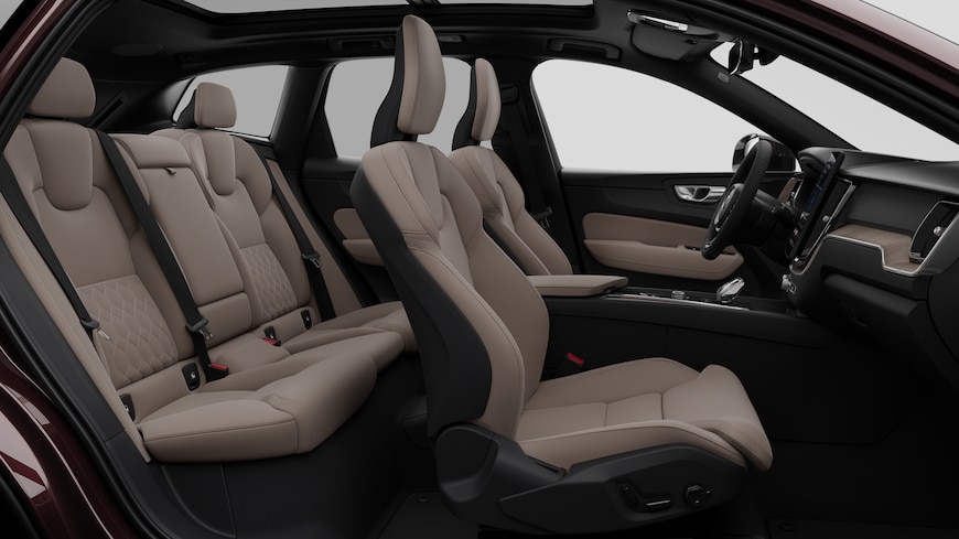 Vista lateral do interior do automóvel Volvo a mostrar os bancos dianteiros, os bancos do passageiro traseiro, o volante, o painel de instrumentos e a consola central, contra um fundo de estúdio simples.