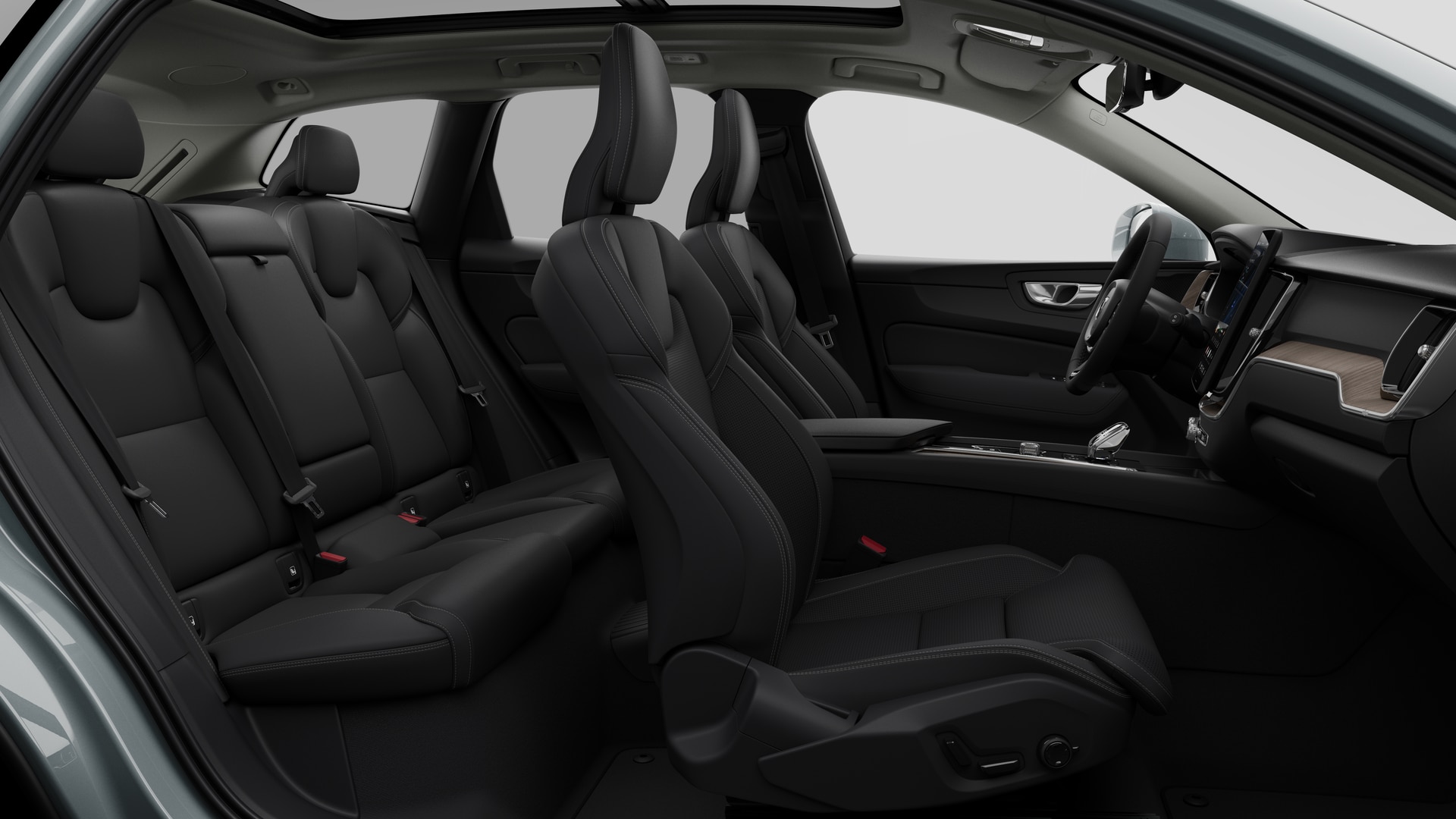 Vue latérale de l’intérieur d’une Volvo montrant les sièges avant, les sièges passager arrière, le volant, le tableau de bord et la console centrale, sur fond de studio.