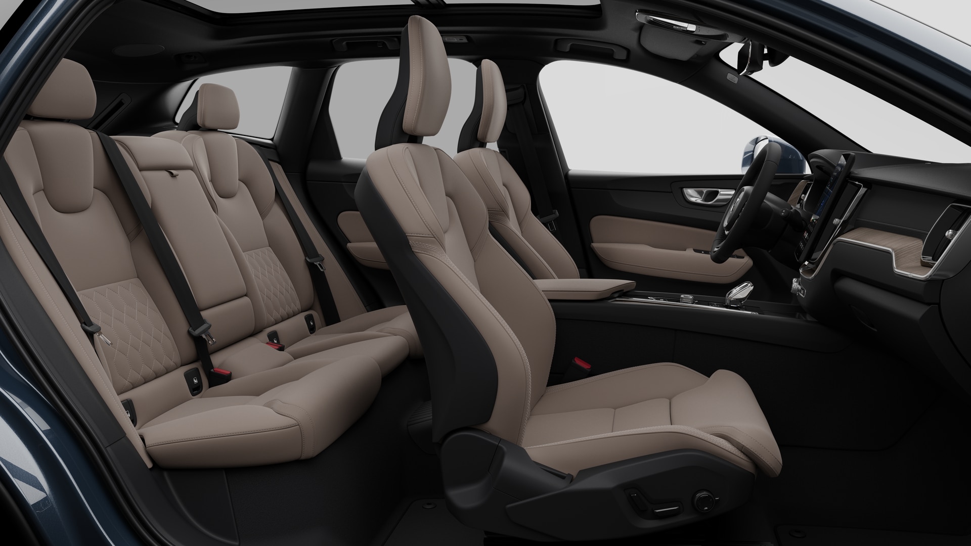 Vue latérale de l’intérieur d’une Volvo montrant les sièges avant, les sièges passager arrière, le volant, le tableau de bord et la console centrale, sur fond de studio.