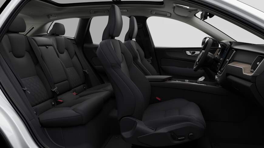 Volvo car interior side view showcasing front seats, rear passenger seats, steering wheel, dashboard, and center console, set against plain studio background.