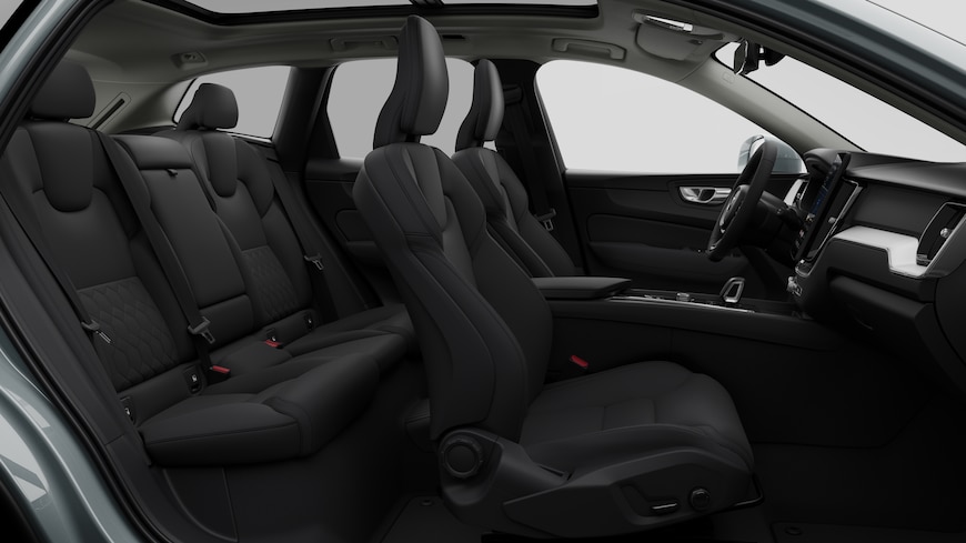 Vista lateral do interior do automóvel Volvo a mostrar os bancos dianteiros, os bancos do passageiro traseiro, o volante, o painel de instrumentos e a consola central, contra um fundo de estúdio simples.