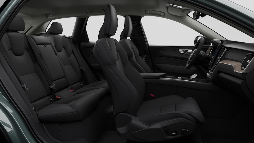 Sidovy av Volvobilens interiör som visar framsäten, bakre passagerarsäten, ratt, instrumentbräda och mittkonsol mot en vanlig studiobakgrund.