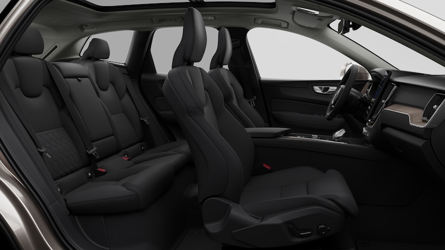 Vista lateral do interior do automóvel Volvo a mostrar os bancos dianteiros, os bancos do passageiro traseiro, o volante, o painel de instrumentos e a consola central, contra um fundo de estúdio simples.