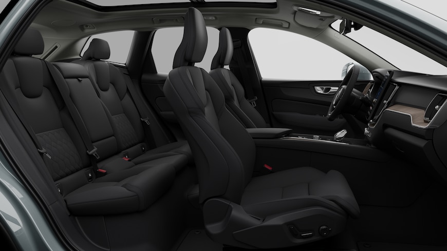 Vista lateral do interior do automóvel Volvo a mostrar os bancos dianteiros, os bancos do passageiro traseiro, o volante, o painel de instrumentos e a consola central, contra um fundo de estúdio simples.