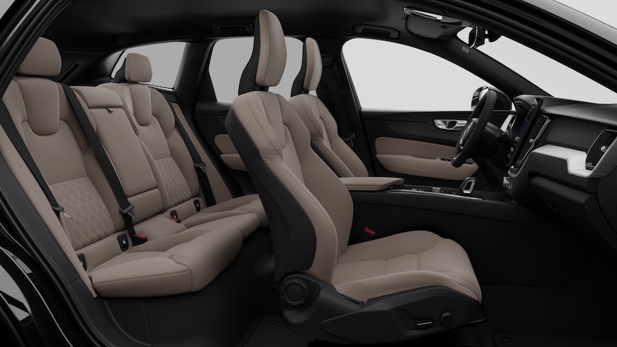 Vista lateral do interior do automóvel Volvo a mostrar os bancos dianteiros, os bancos do passageiro traseiro, o volante, o painel de instrumentos e a consola central, contra um fundo de estúdio simples.