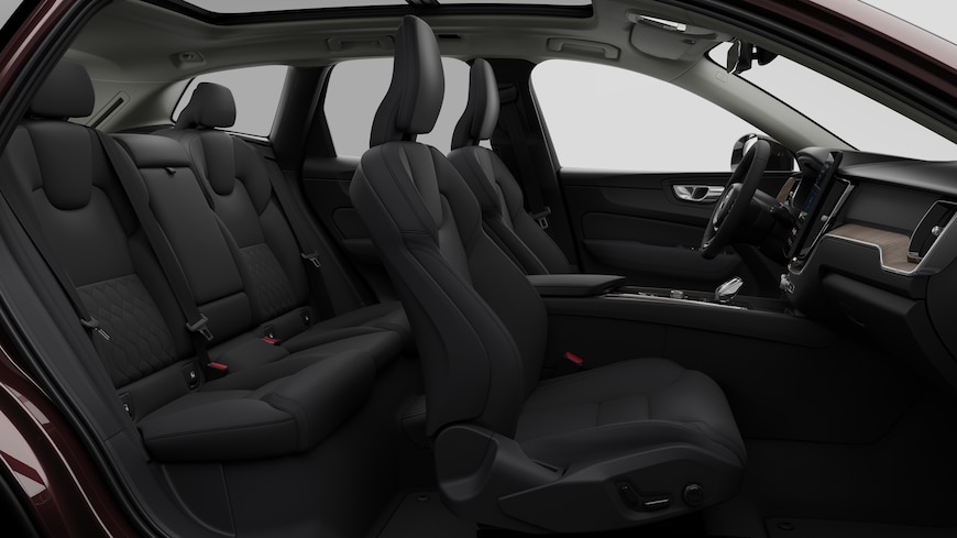 Volvo car interior side view showcasing front seats, rear passenger seats, steering wheel, dashboard, and center console, set against plain studio background.