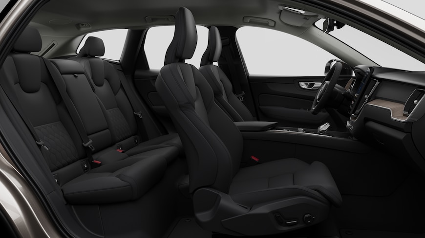 Sidovy av Volvobilens interiör som visar framsäten, bakre passagerarsäten, ratt, instrumentbräda och mittkonsol mot en vanlig studiobakgrund.