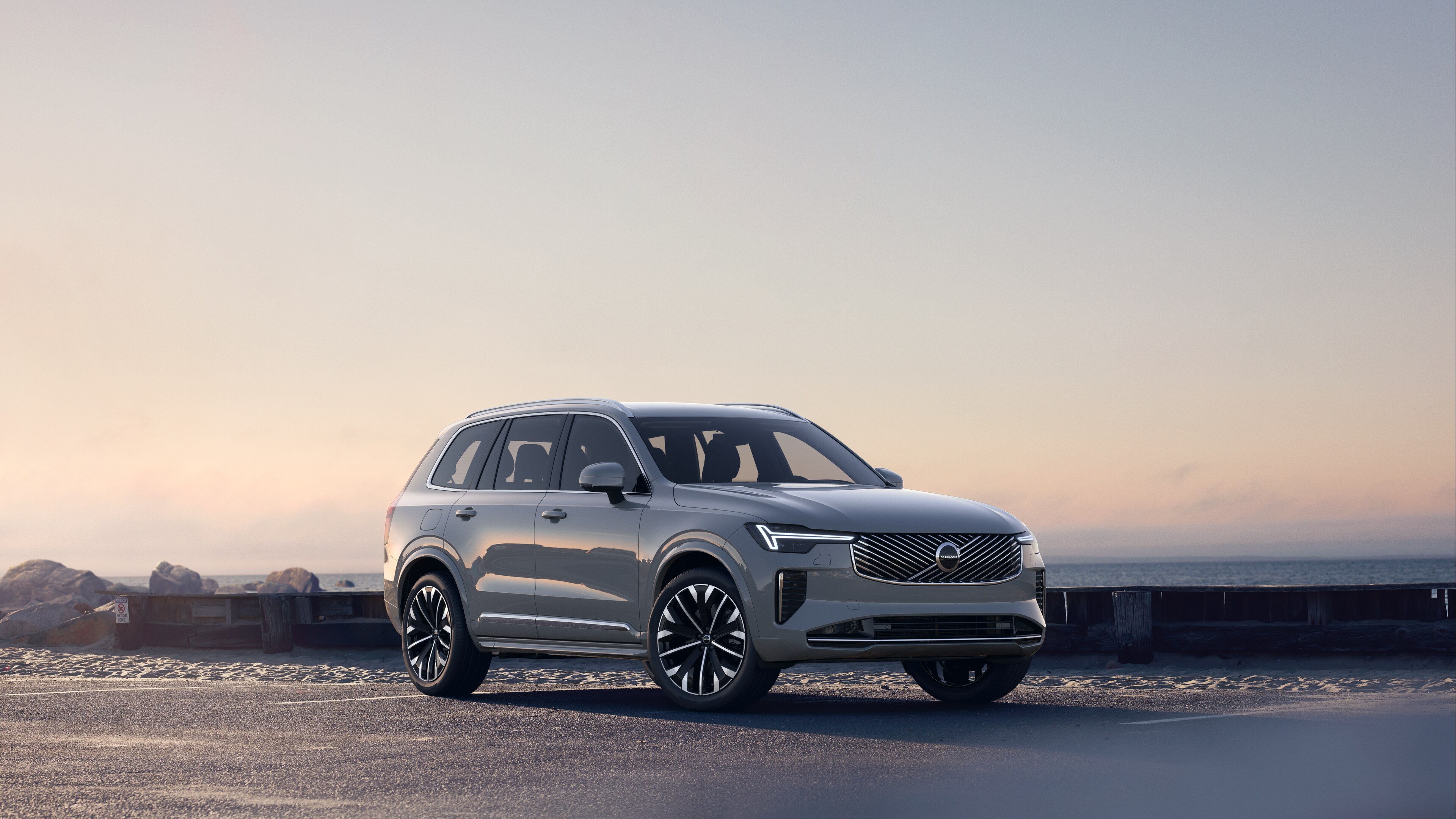 Volvo-bil med trekvart visning av kystveien, som viser forsiden og siden mot en rolig havbakgrunn.