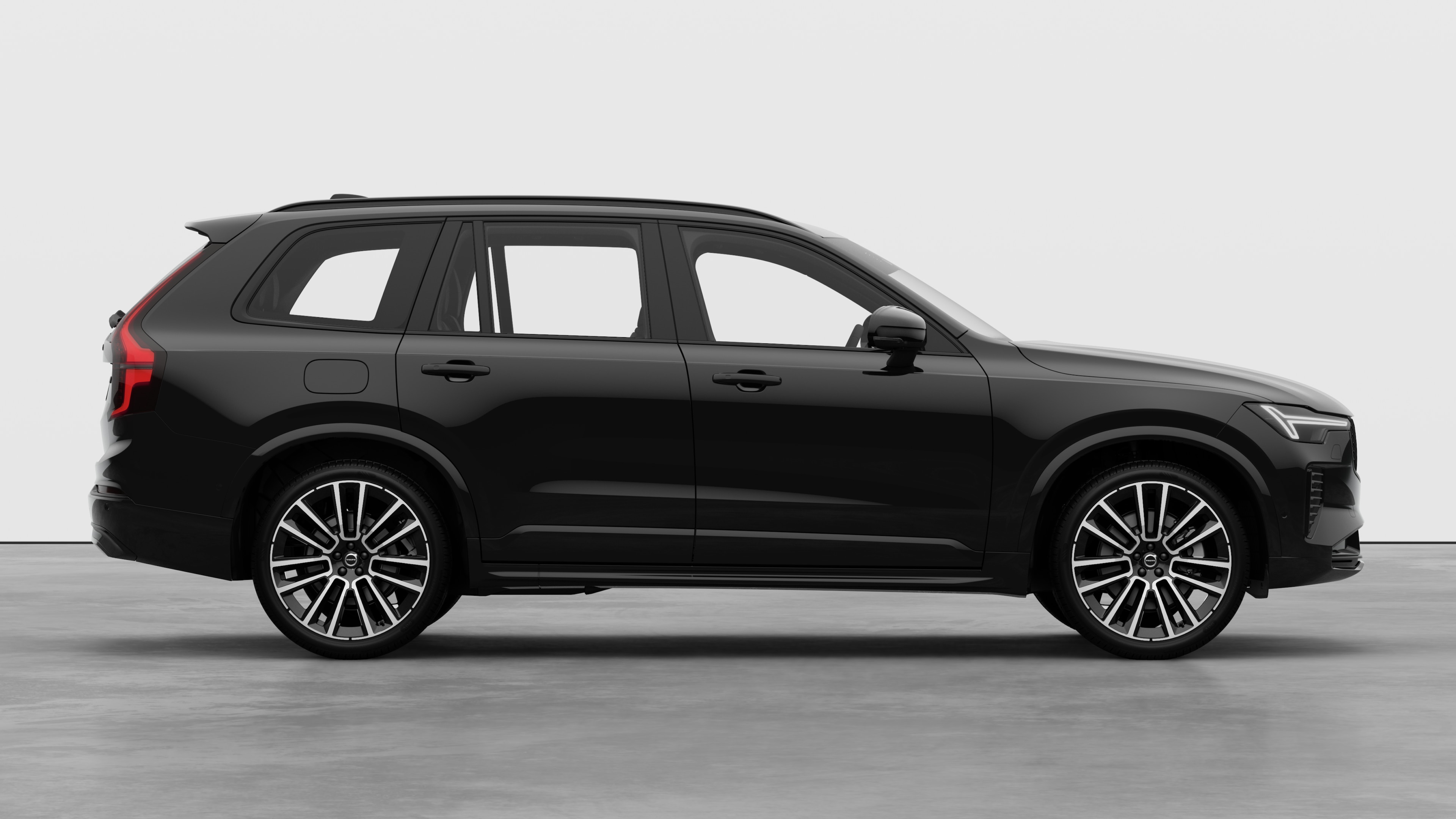 Zijaanzicht van de Volvo-auto op een effen studioachtergrond met gesloten deuren en een zichtbaar wielontwerp.