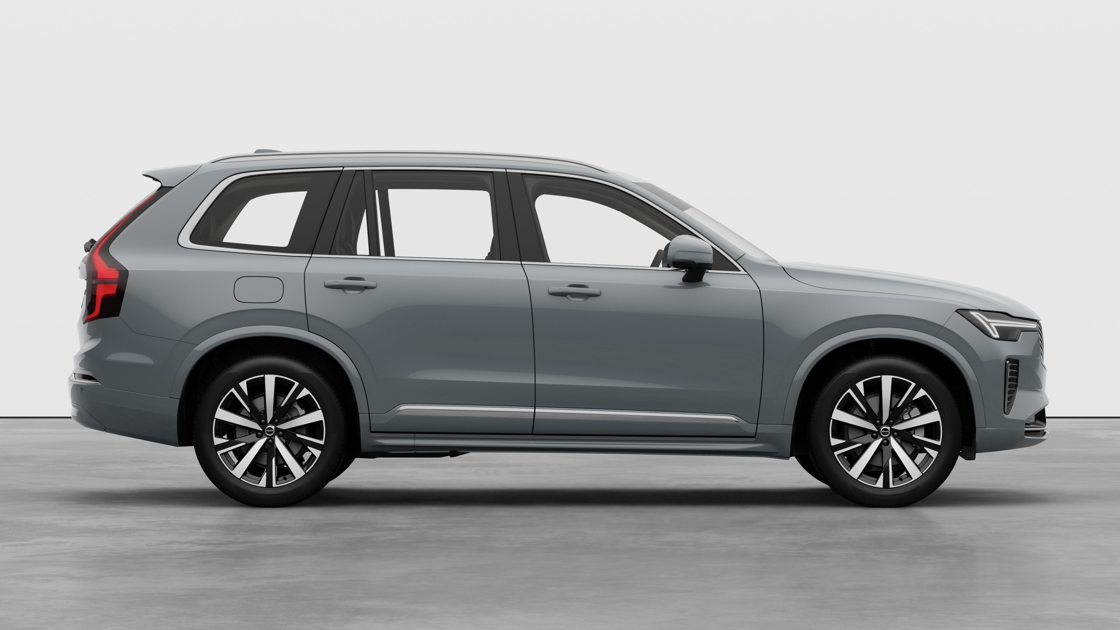 Seitenansicht eines Volvo Fahrzeugs auf einem schlichten Studiohintergrund mit geschlossenen Türen und sichtbarem Raddesign.