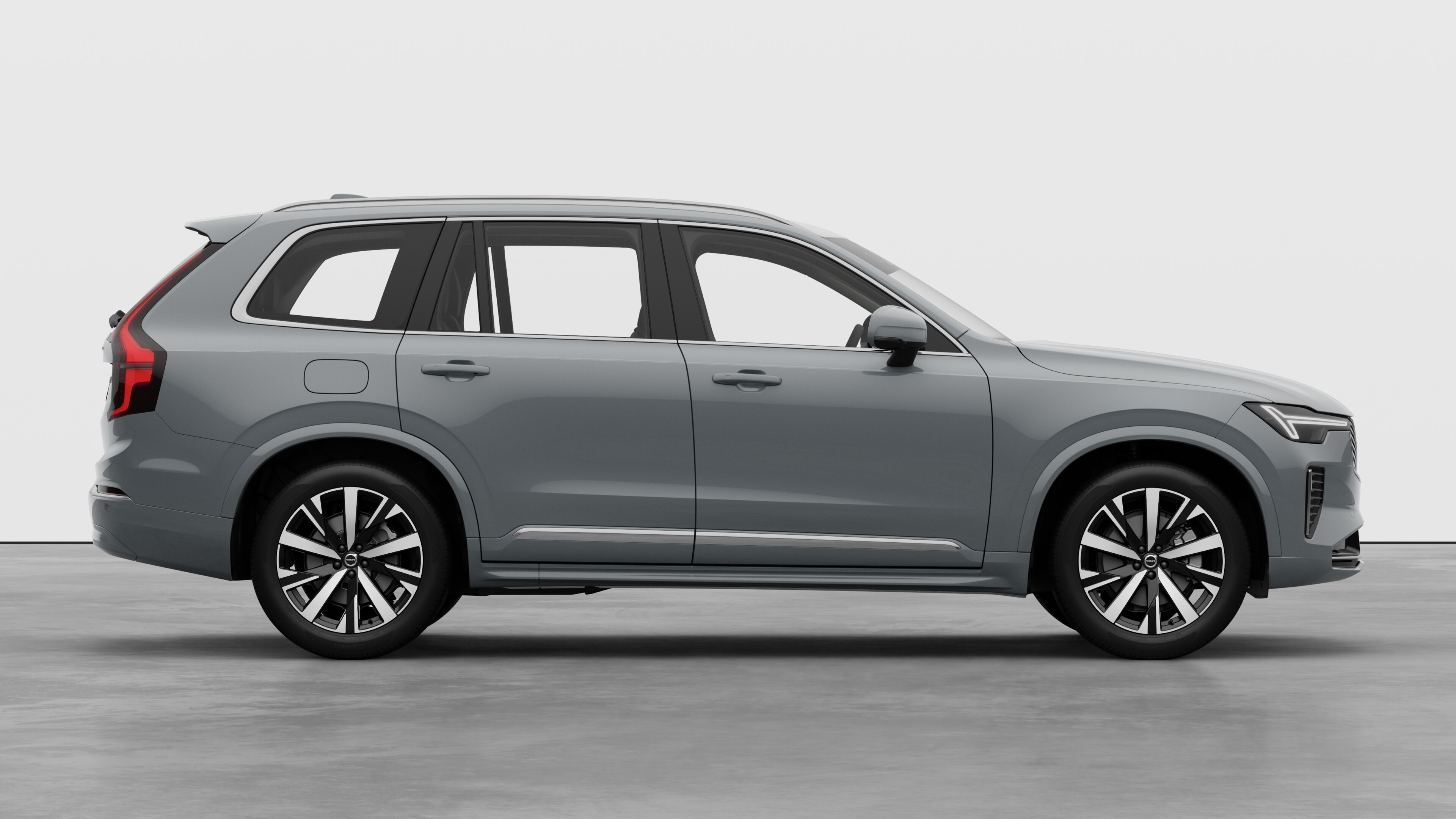 Zijaanzicht van een Volvo op een eenvoudige studioachtergrond met gesloten deuren en zichtbaar wielontwerp.