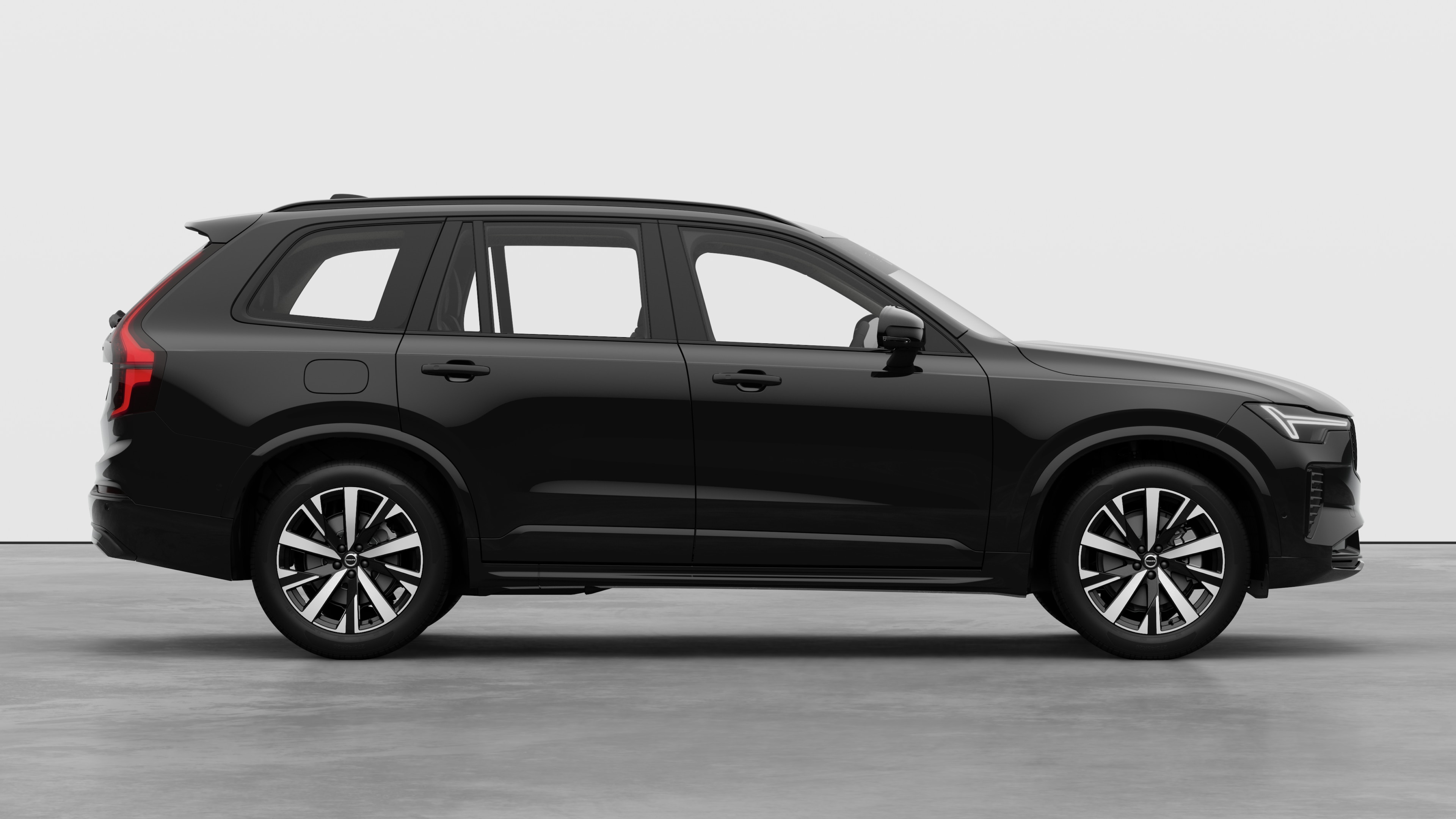 Volvo car side view on plain studio background displaying closed doors and visible wheel design.
