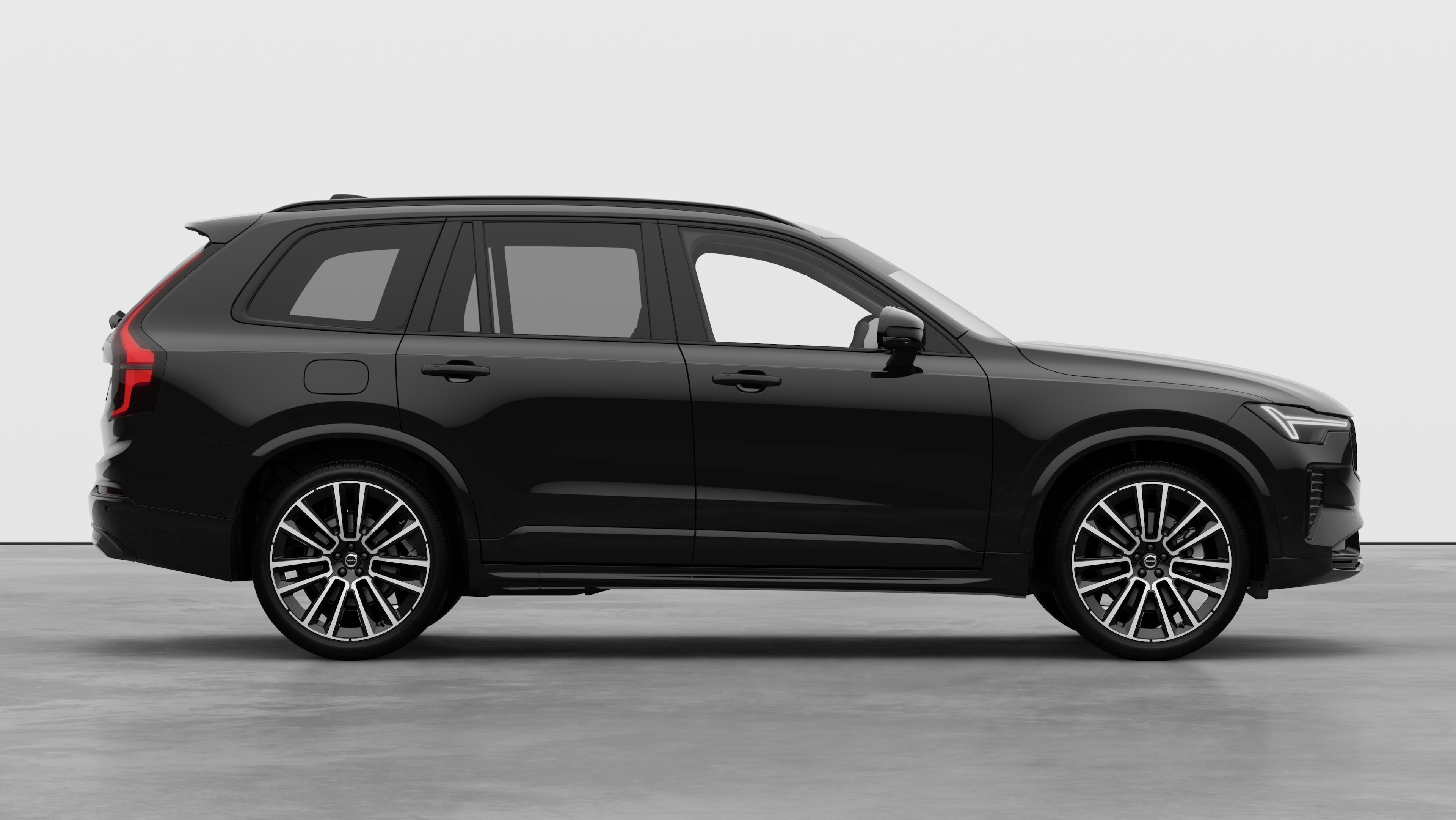 Volvo car side view on plain studio background displaying closed doors and visible wheel design.