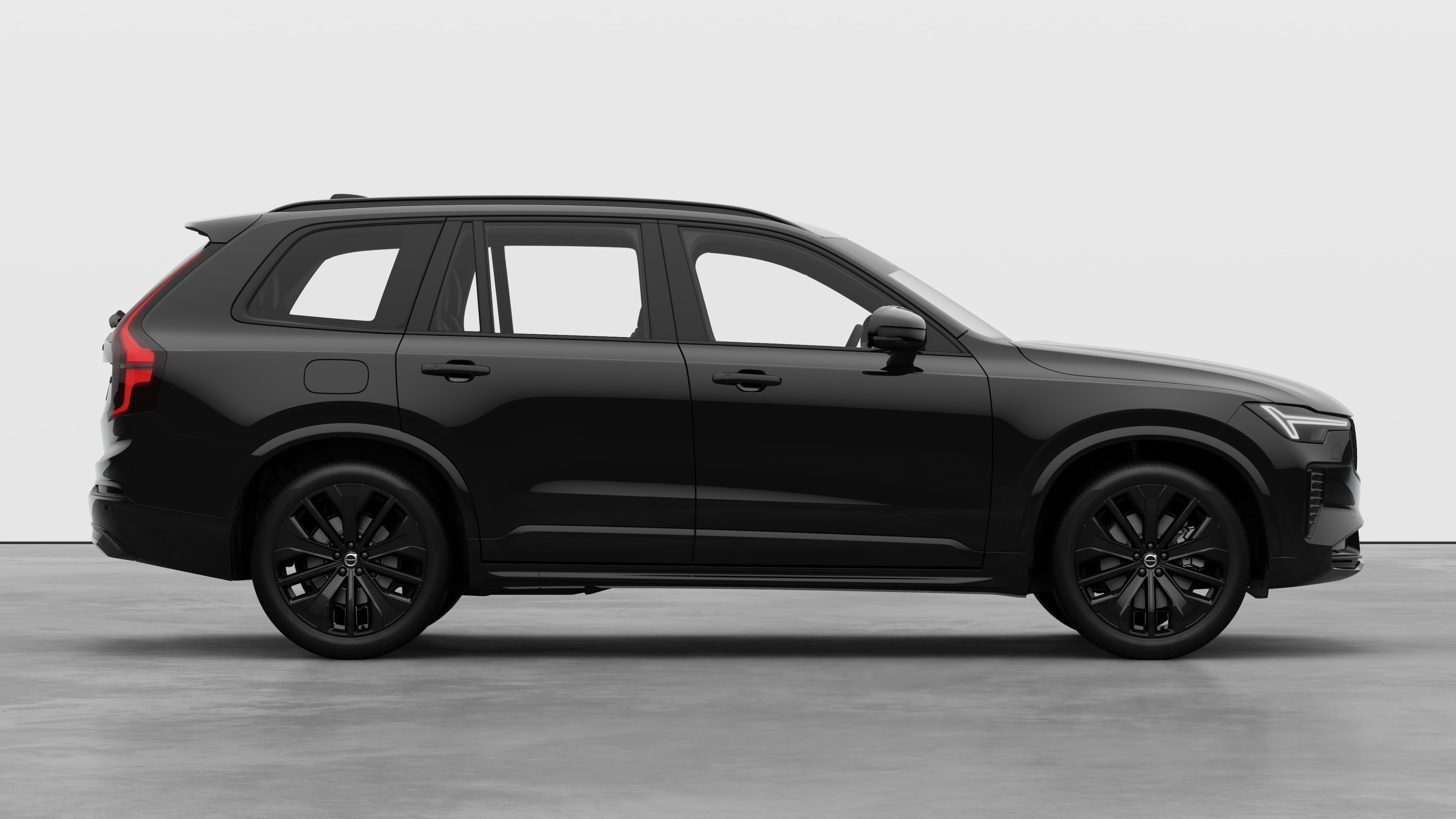 Zijaanzicht van de Volvo-auto op een effen studioachtergrond met gesloten deuren en een zichtbaar wielontwerp.