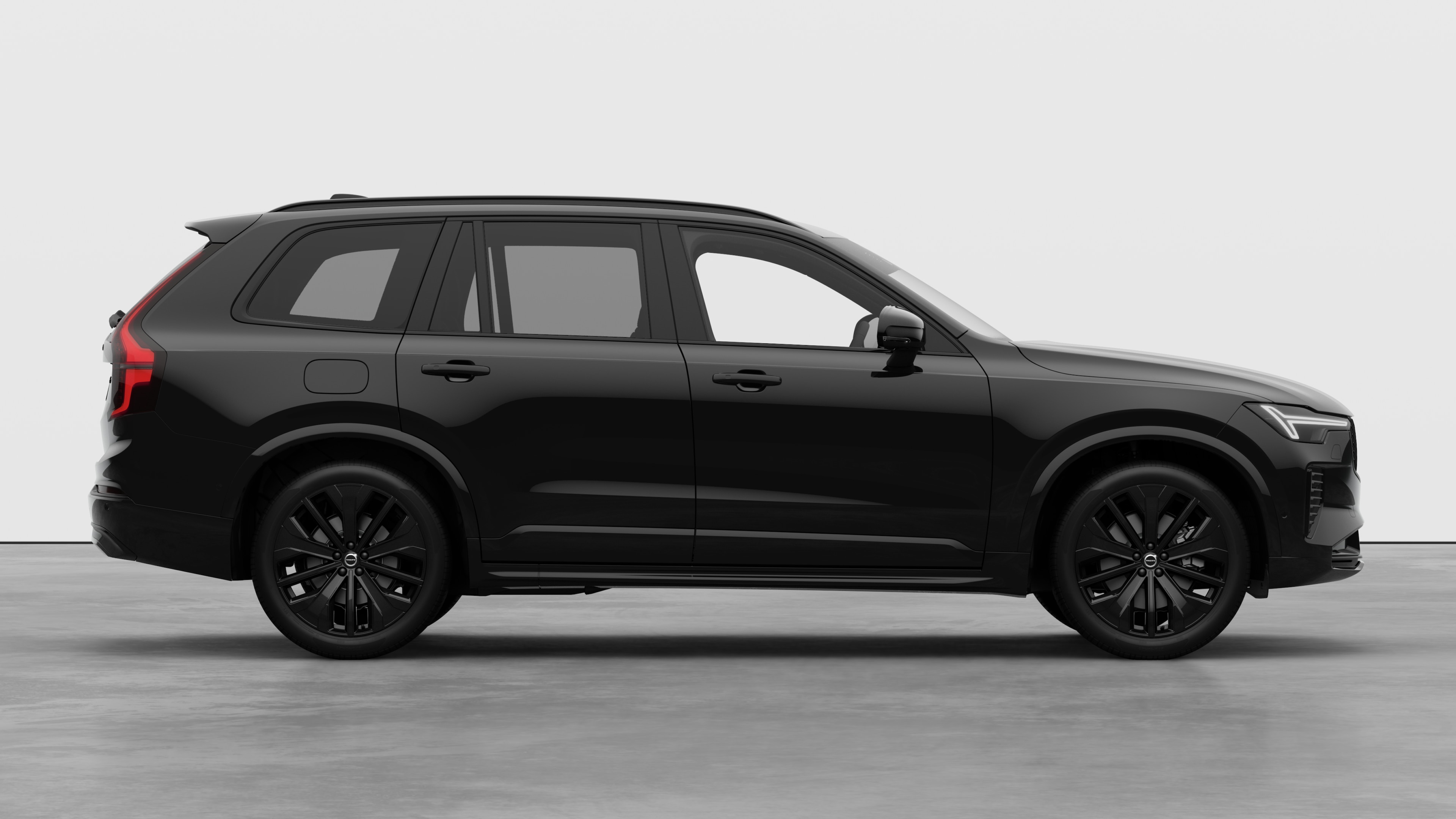 Volvo car side view on plain studio background displaying closed doors and visible wheel design.