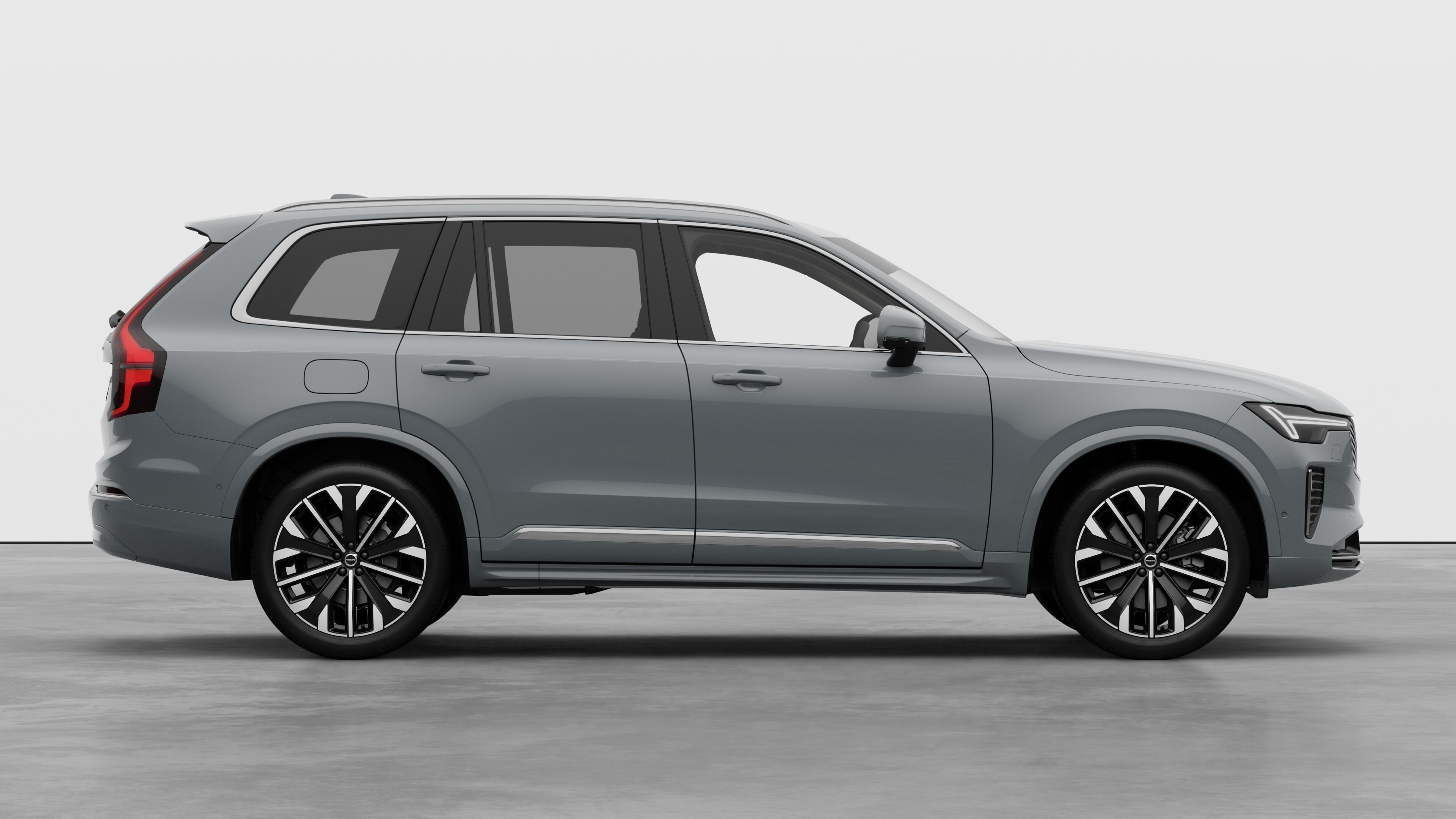 Volvo car side view on plain studio background displaying closed doors and visible wheel design.
