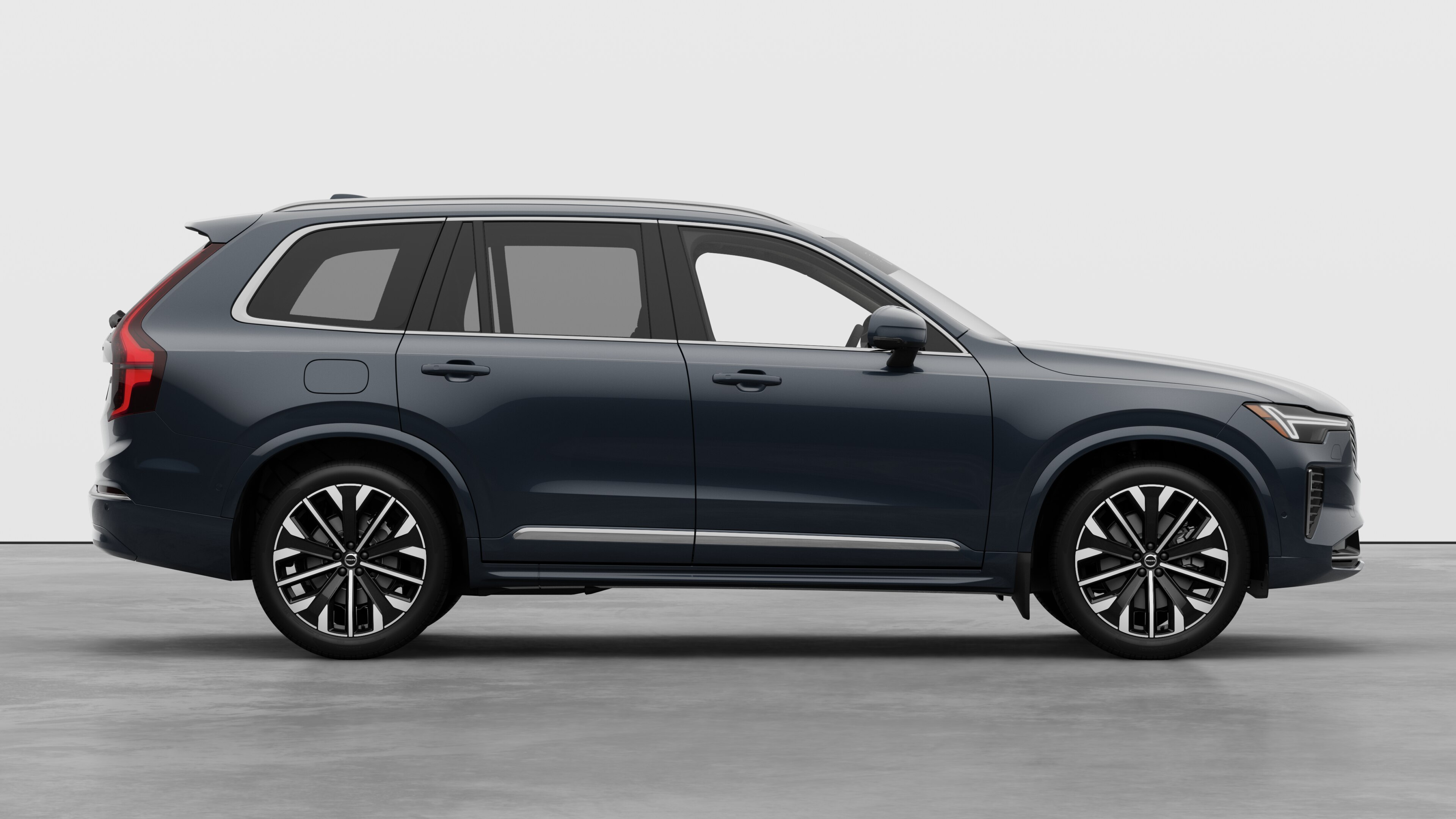 Volvo car side view on plain studio background displaying closed doors and visible wheel design.