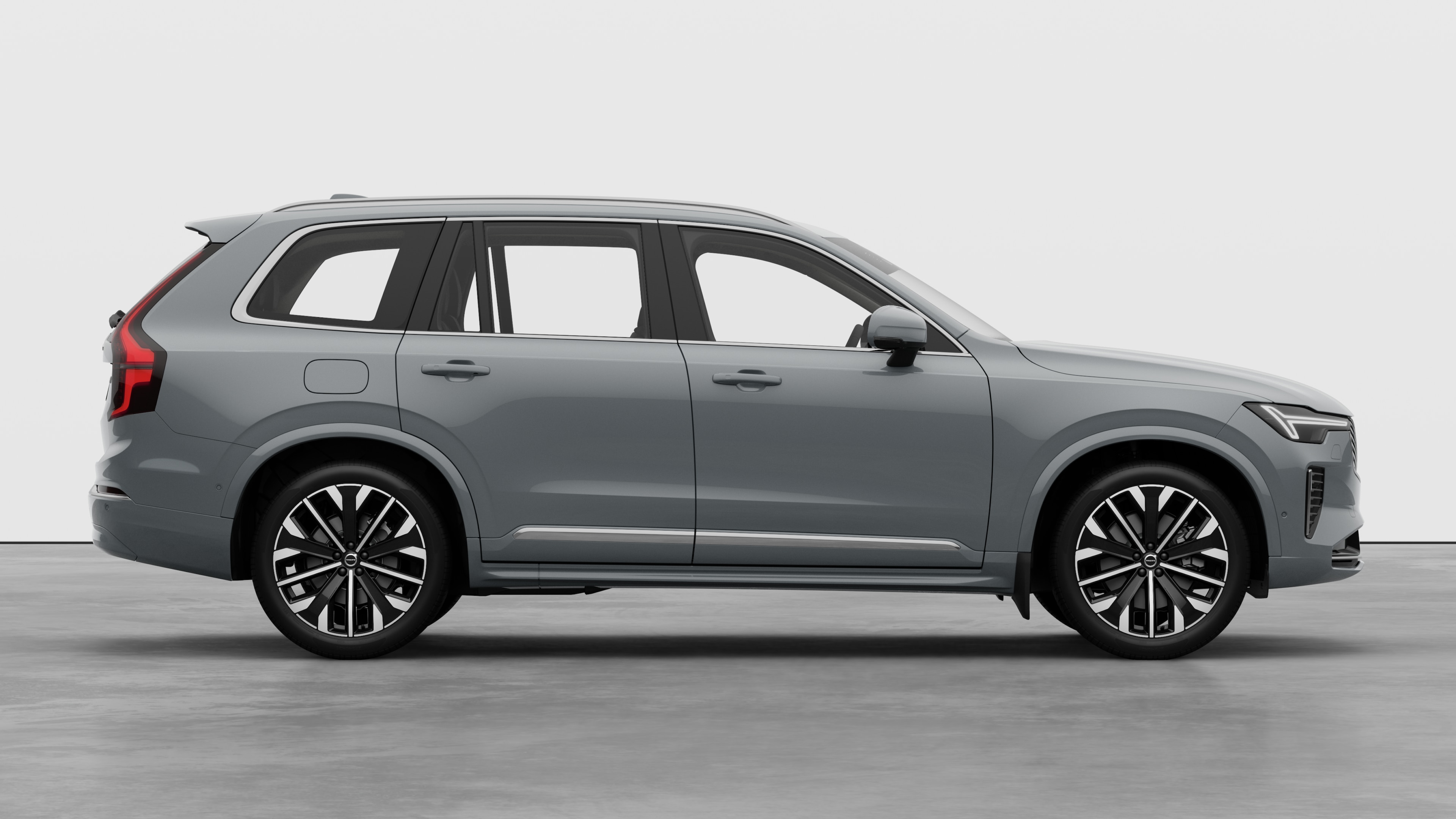 Sidovy från Volvo-bilen på en vanlig studiobakgrund som visar stängda dörrar och synlig fälgdesign.
