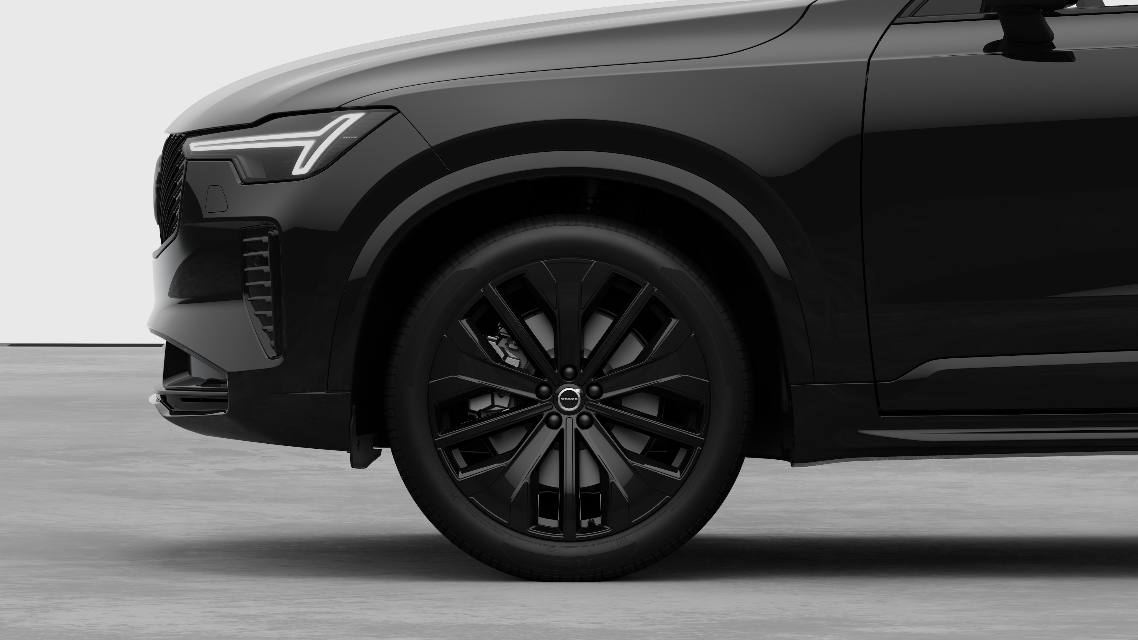 Vue latérale extérieure de la Volvo se concentrant sur la roue avant et l’aile, sur un fond de studio uni.
