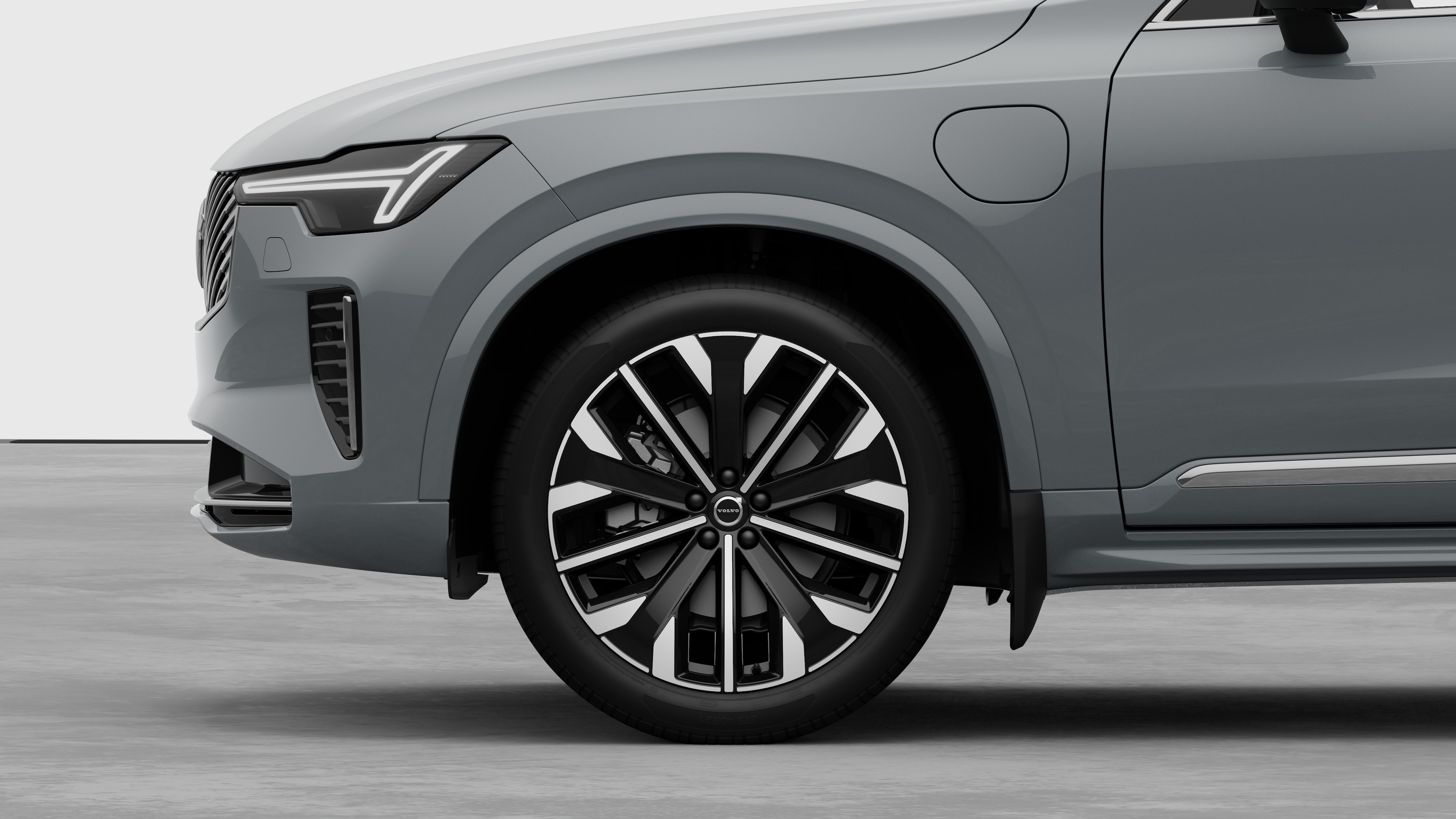 Volvos utvendige sidevisning med fokus på forhjulet og skjermen, satt mot en vanlig studiobakgrunn.