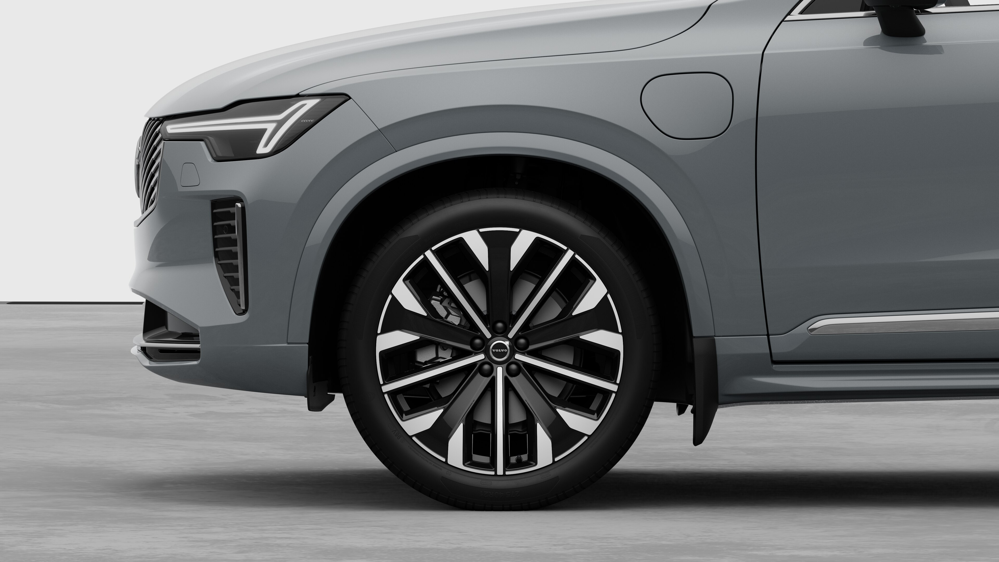 Volvos utvendige sidevisning med fokus på forhjulet og skjermen, satt mot en vanlig studiobakgrunn.