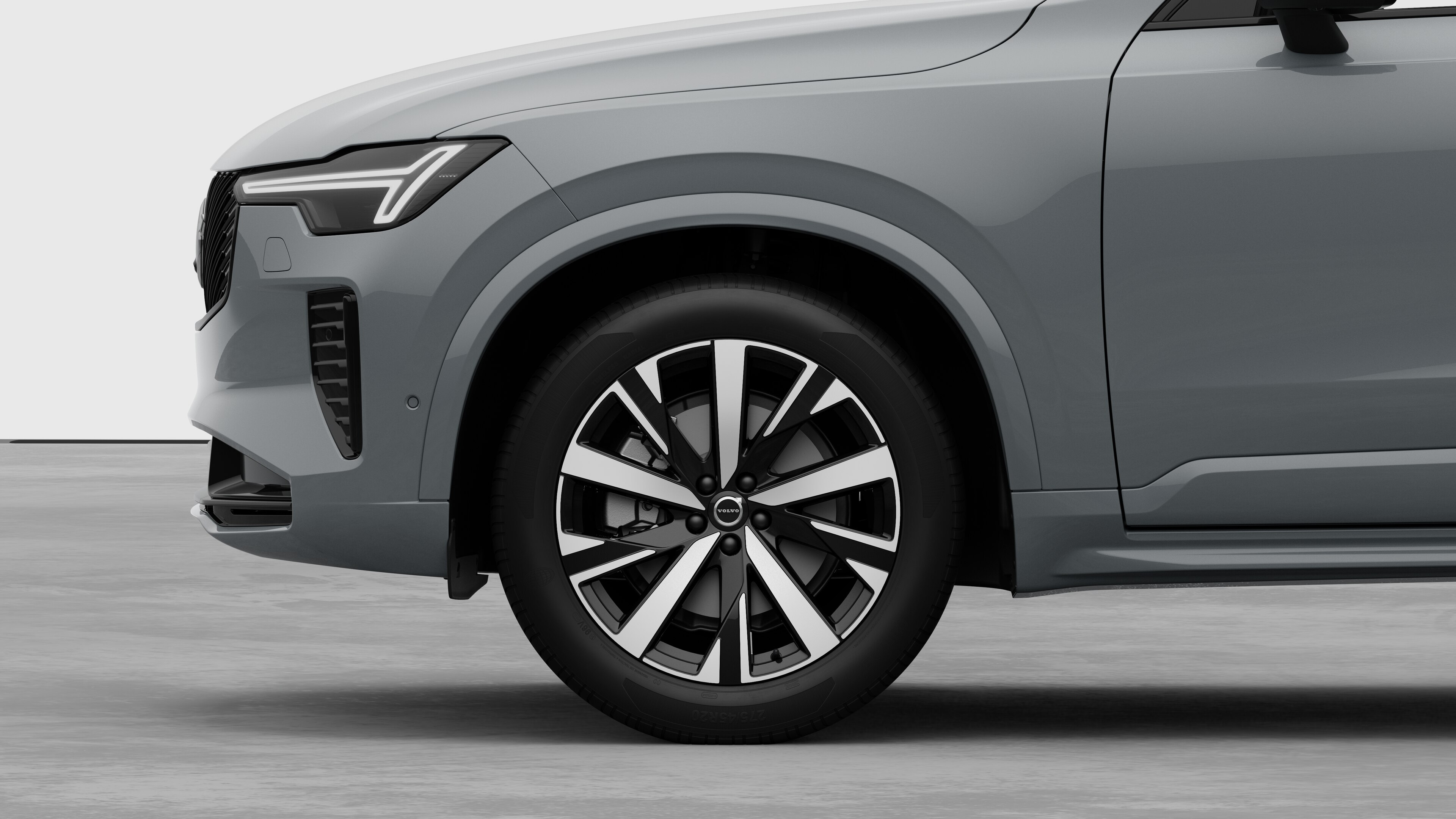 Volvo car exterior side view focusing on the front wheel and fender, set against a plain studio background.