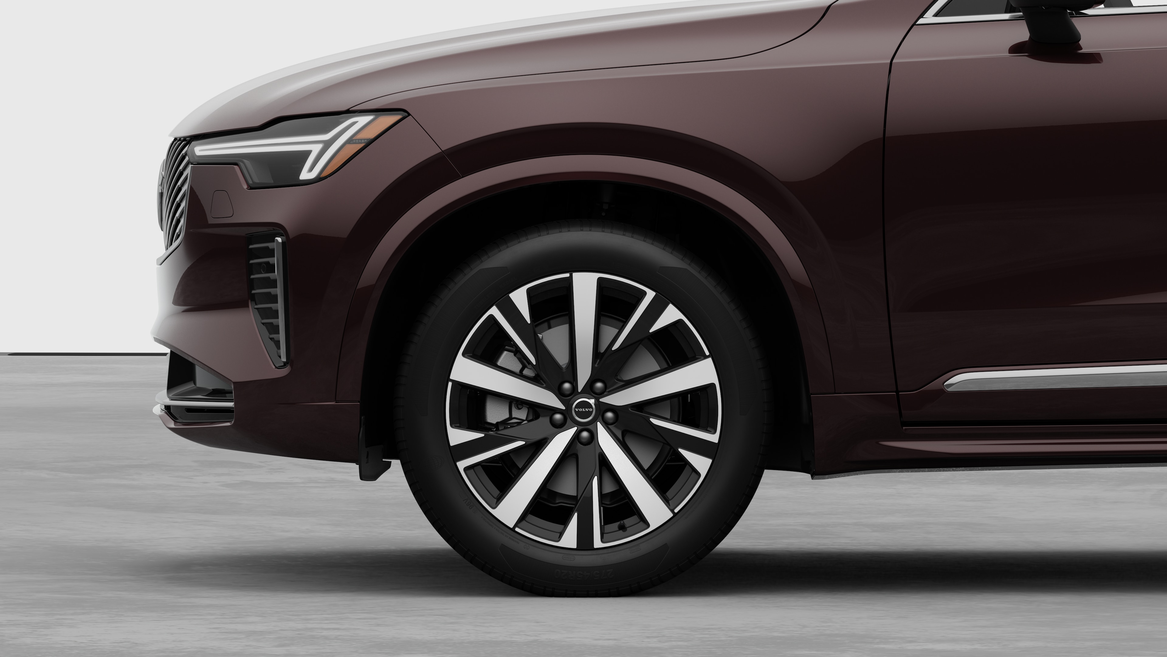 Volvo car exterior side view focusing on the front wheel and fender, set against a plain studio background.