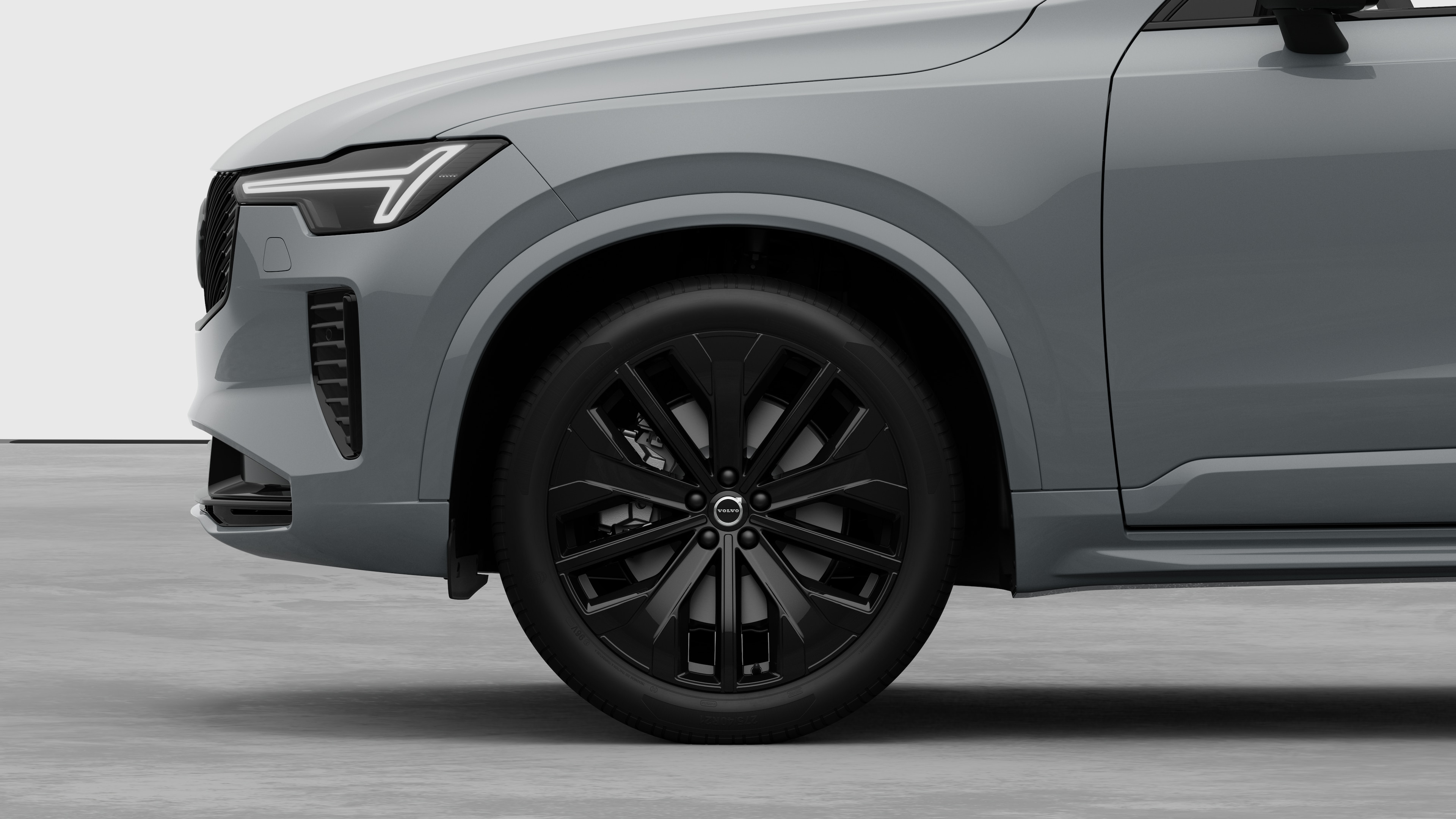 Seitenansicht eines Volvo Fahrzeugs mit Fokus auf Vorderrad und Kotflügel vor einem schlichten Studiohintergrund.