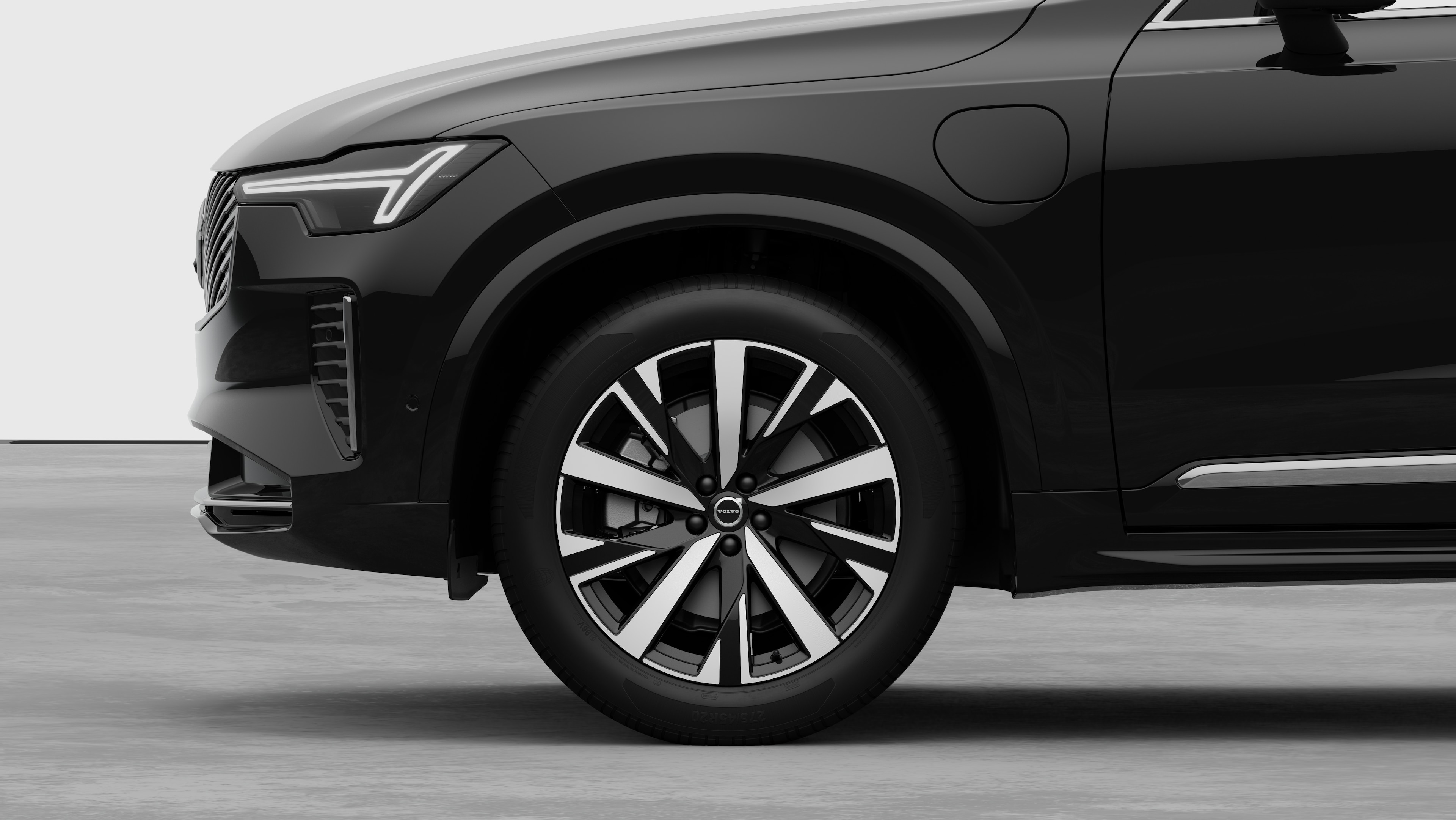 Volvo car exterior side view focusing on the front wheel and fender, set against a plain studio background.