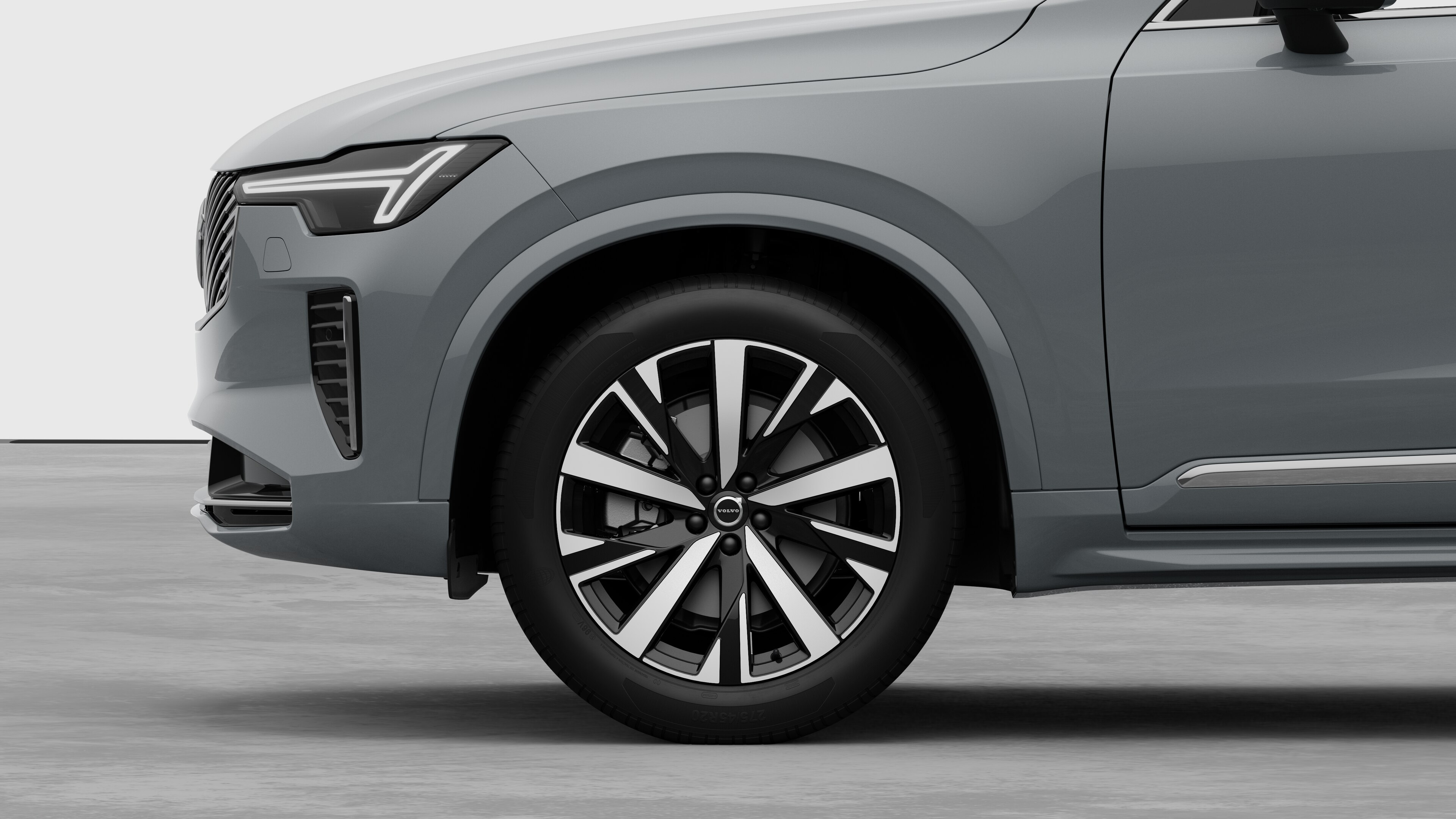 Volvo car exterior side view focusing on the front wheel and fender, set against a plain studio background.