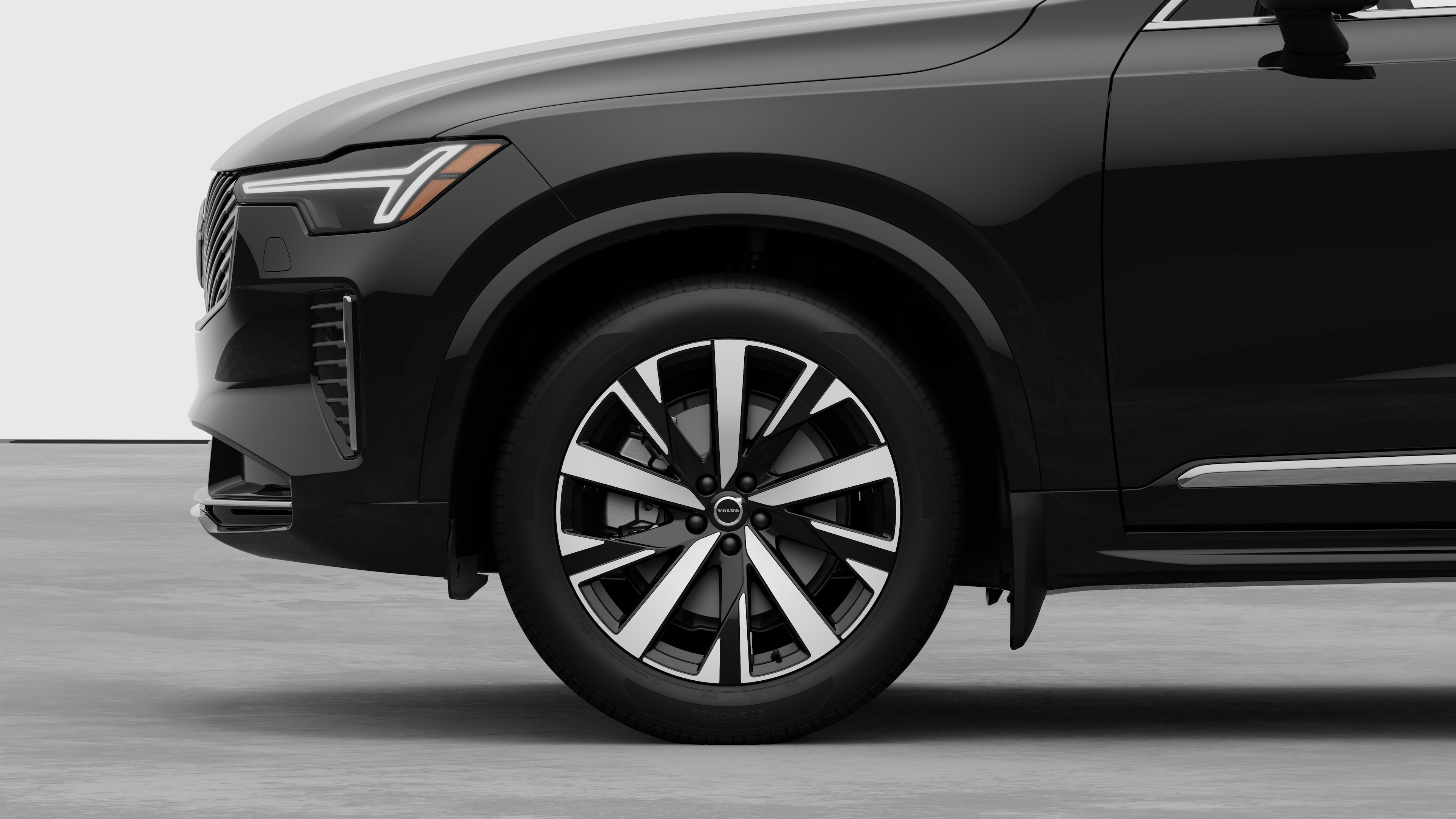 Volvo car exterior side view focusing on the front wheel and fender, set against a plain studio background.