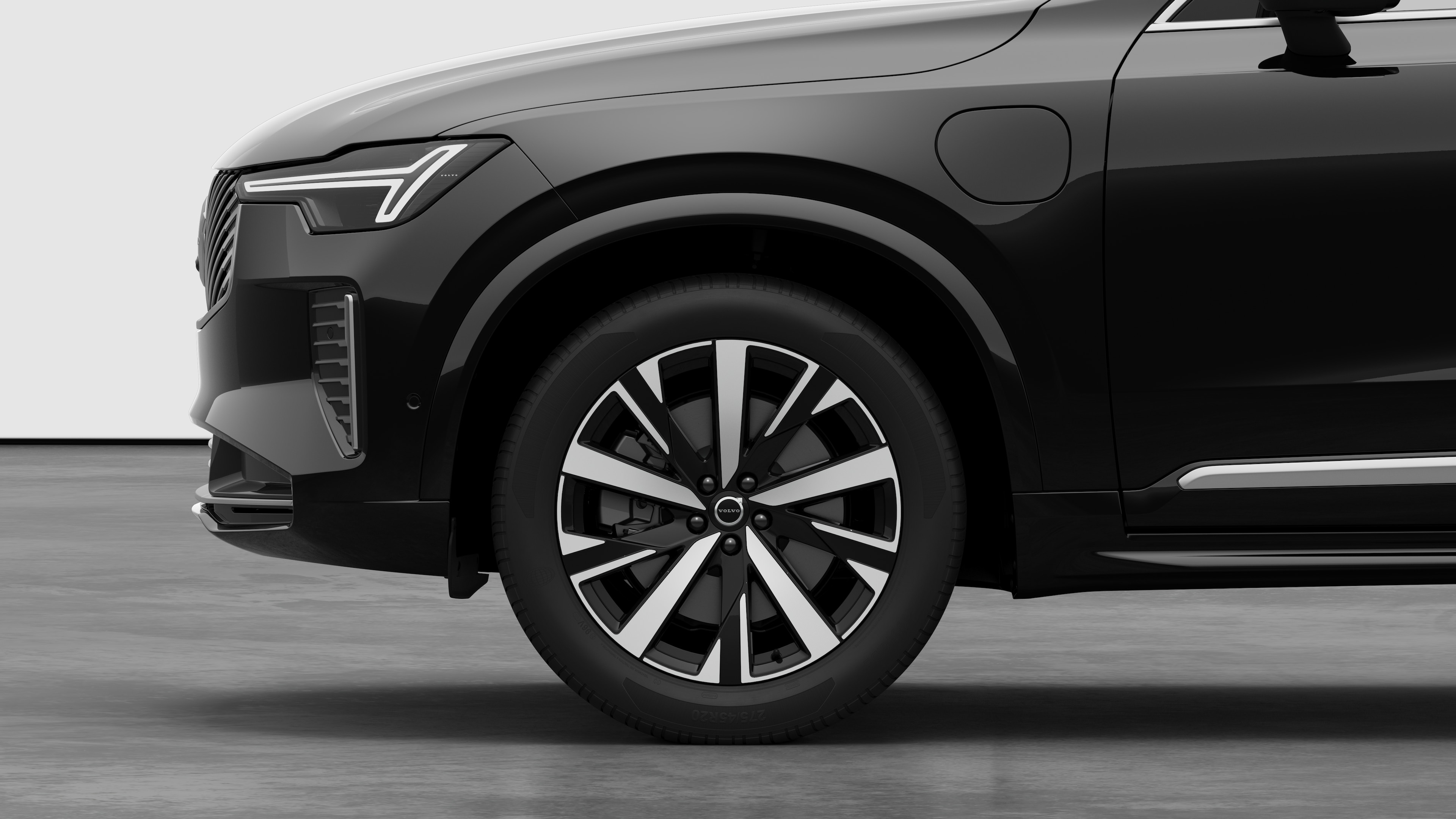 Volvo car exterior side view focusing on the front wheel and fender, set against a plain studio background.