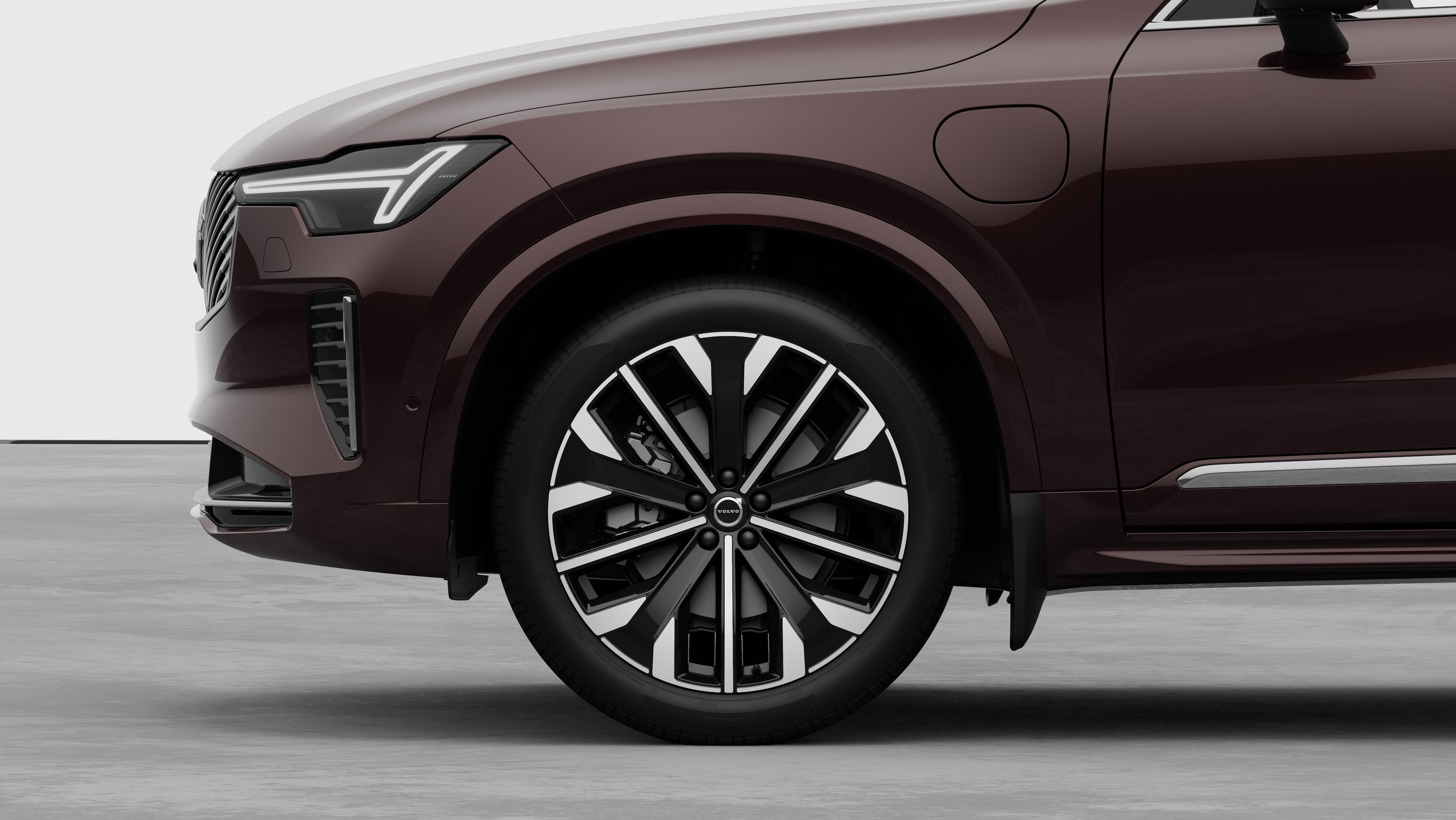 Volvo Cars exteriör sidovy med fokus på framhjul och skärm, mot en enkel studiobakgrund.