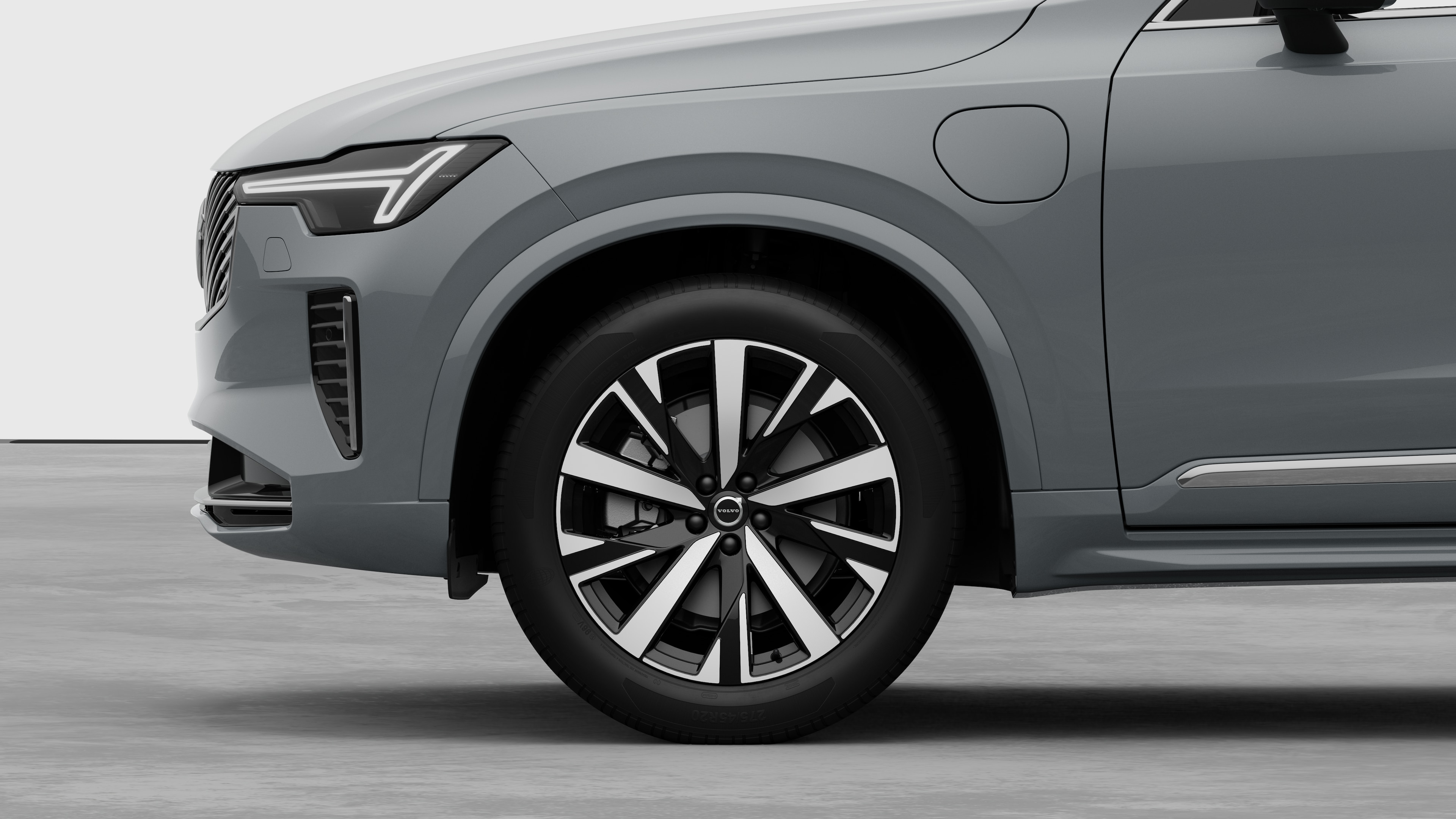 Volvo car exterior side view focusing on the front wheel and fender, set against a plain studio background.