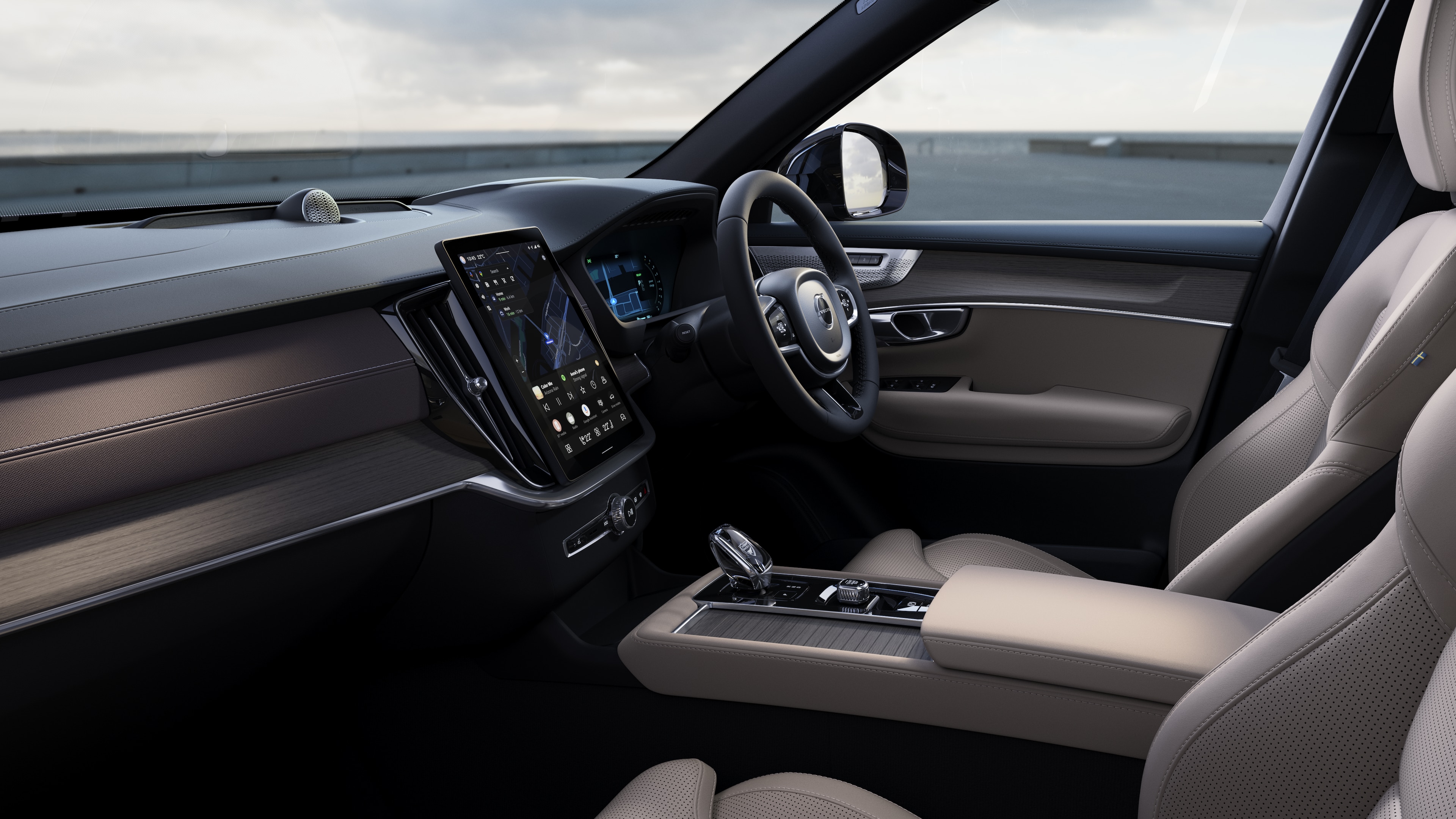 Volvo car interior showing dashboard, steering wheel, and center console with digital display in an open road background.