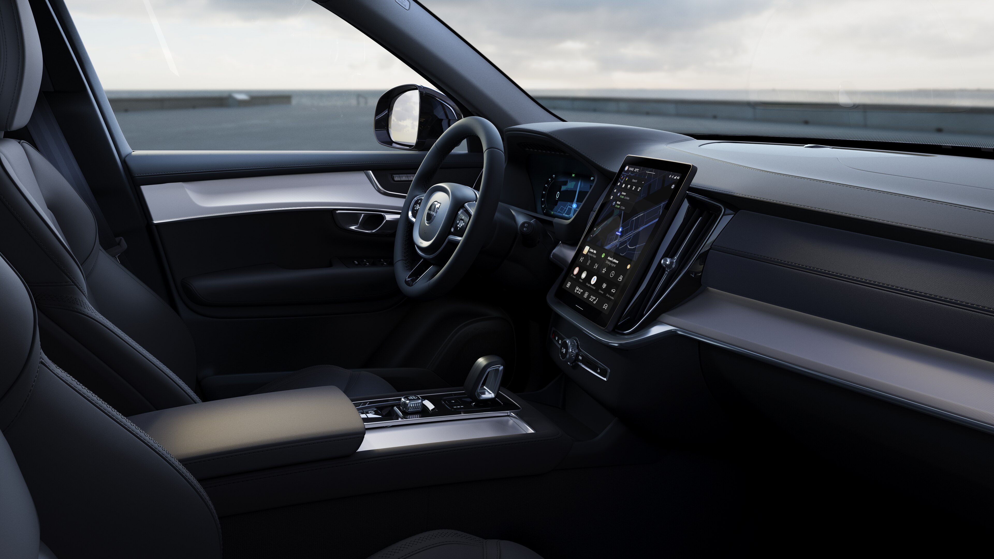 Interior del vehículo Volvo que muestra el salpicadero, el volante y la consola central con pantalla digital en un fondo de carretera abierta.