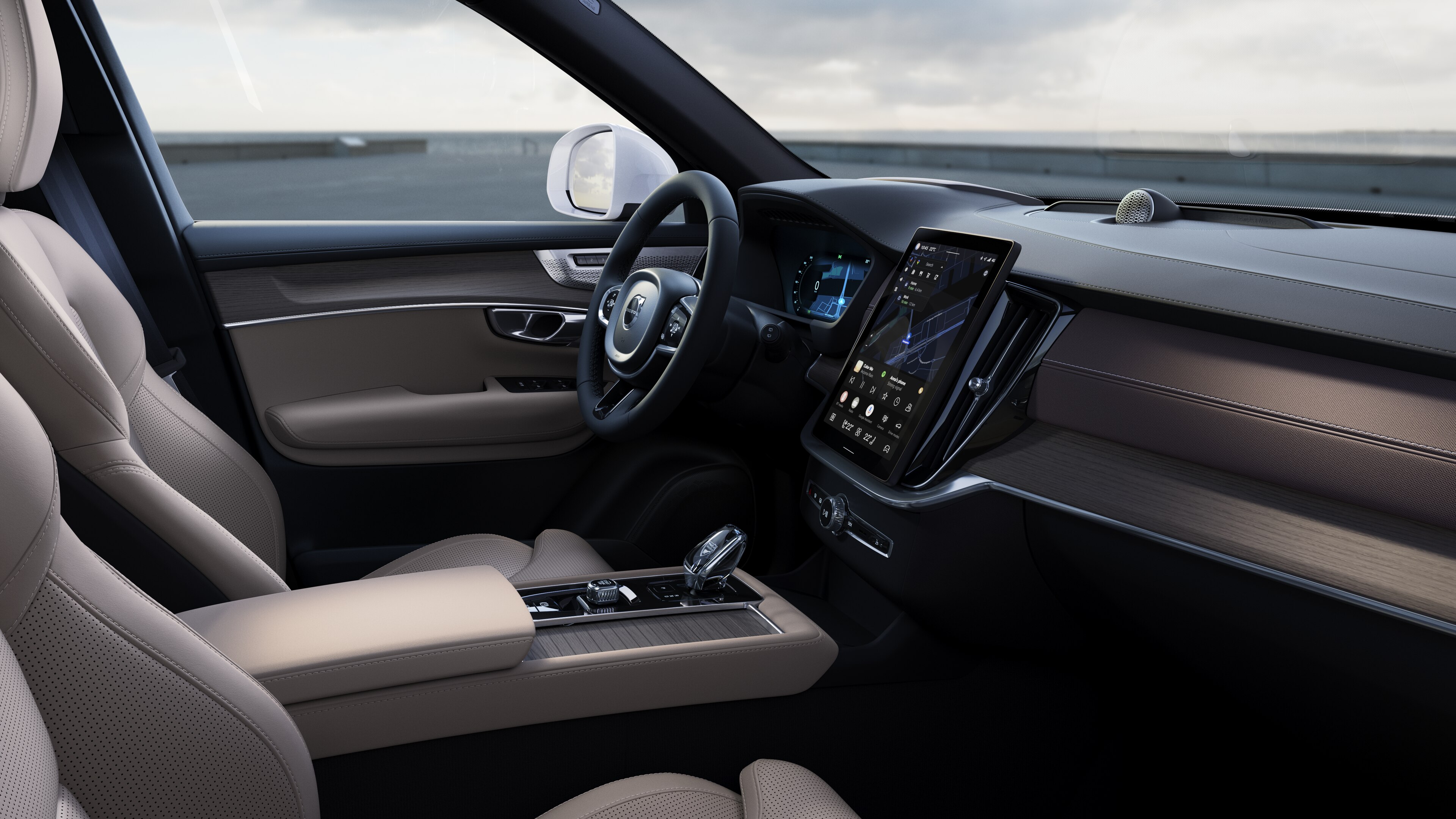 열린 도로 배경에 디지털 디스플레이가 있는 대시보드, 스티어링 휠 및 센터 콘솔을 보여주는 볼보 자동차 내부.