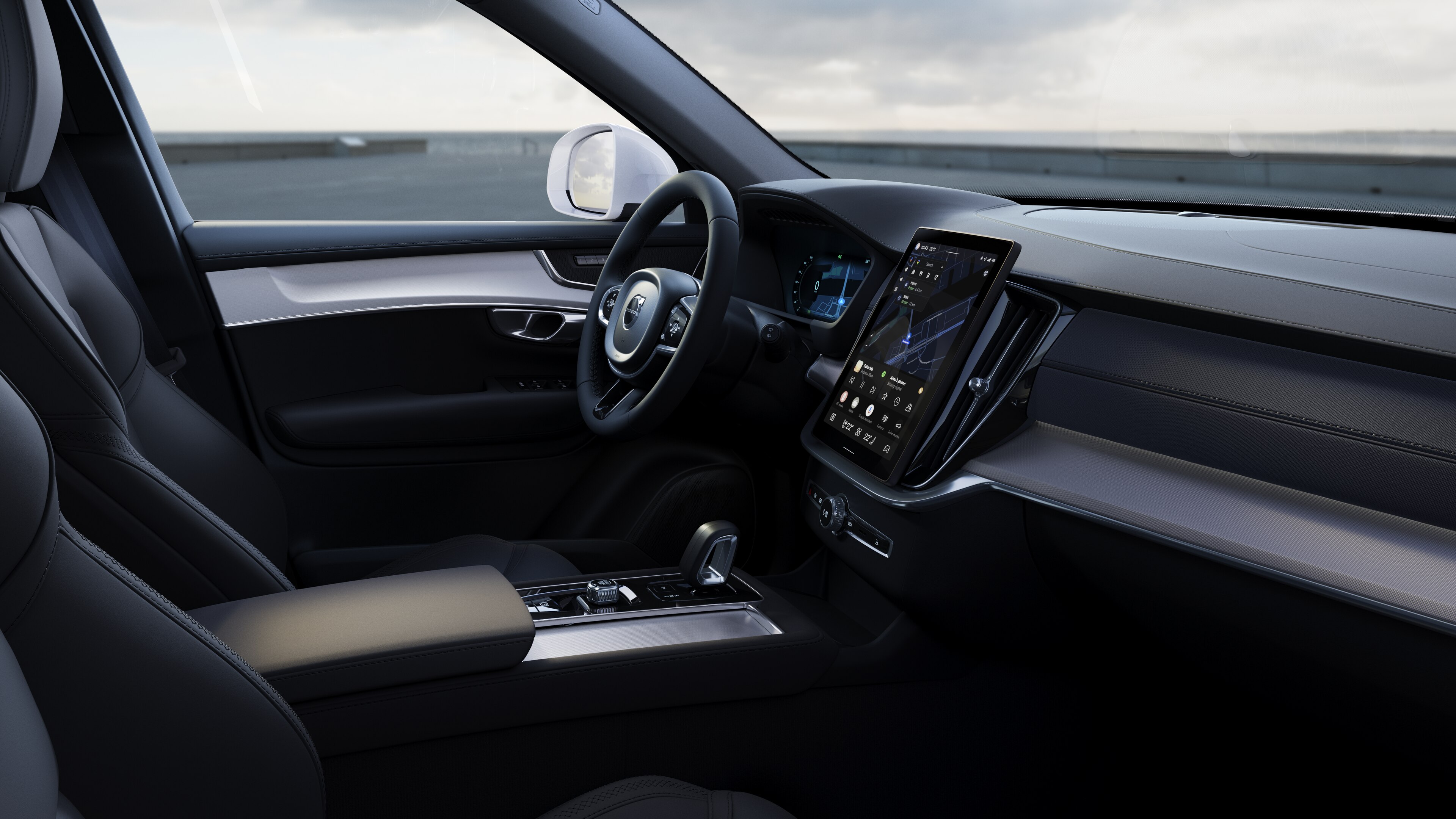 Interior do automóvel Volvo a mostrar o painel de instrumentos, o volante e a consola central com ecrã digital em fundo de estrada aberto.