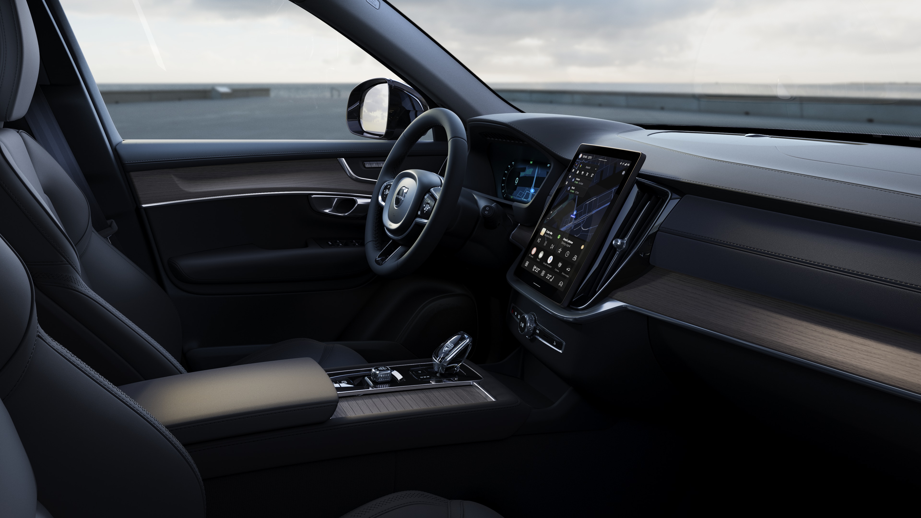 Volvo car interior showing dashboard, steering wheel, and center console with digital display in an open road background.