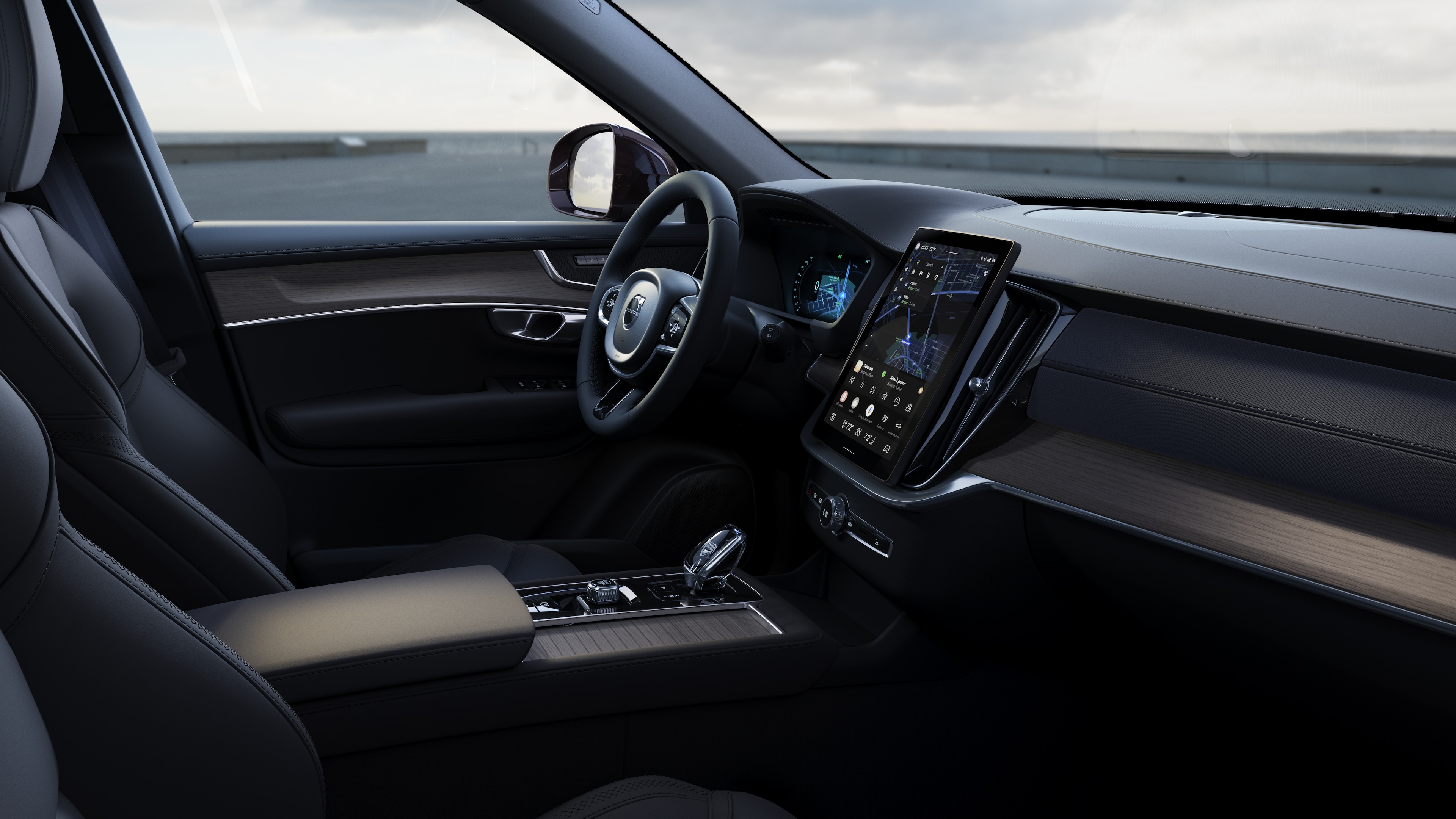 Volvo car interior showing dashboard, steering wheel, and center console with digital display in an open road background.