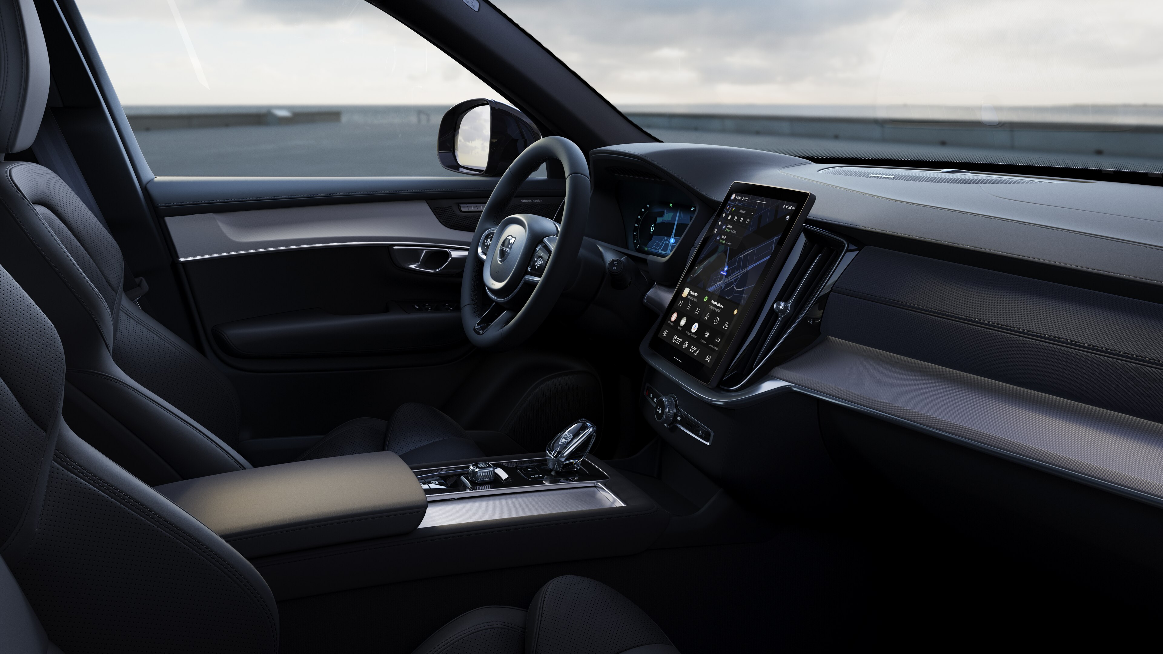 Volvo Fahrzeuginnenraum mit Armaturenbrett, Lenkrad und Mittelkonsole mit Digitaldisplay vor dem Hintergrund der offenen Straße.