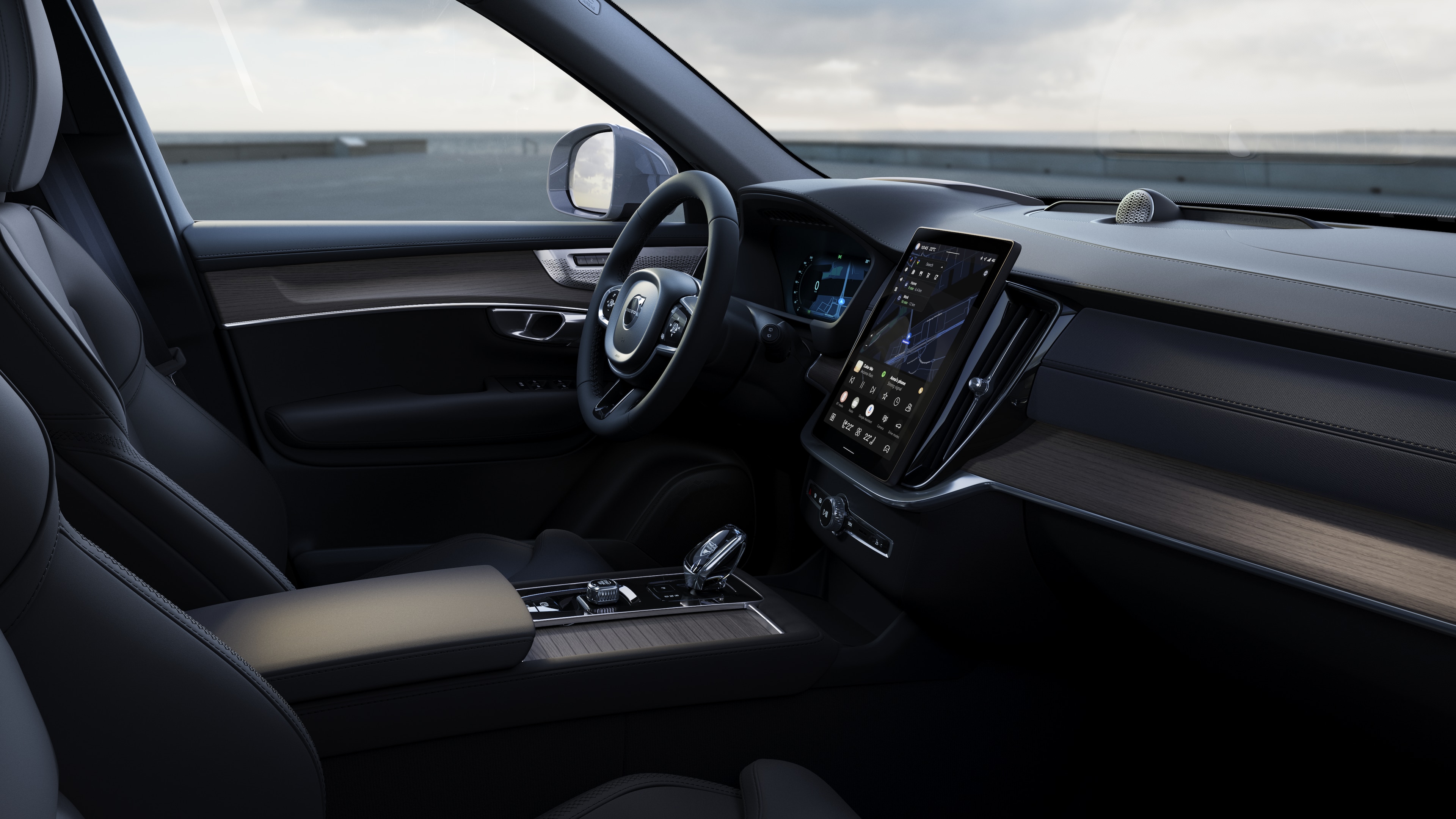 Volvo car interior showing dashboard, steering wheel, and center console with digital display in an open road background.