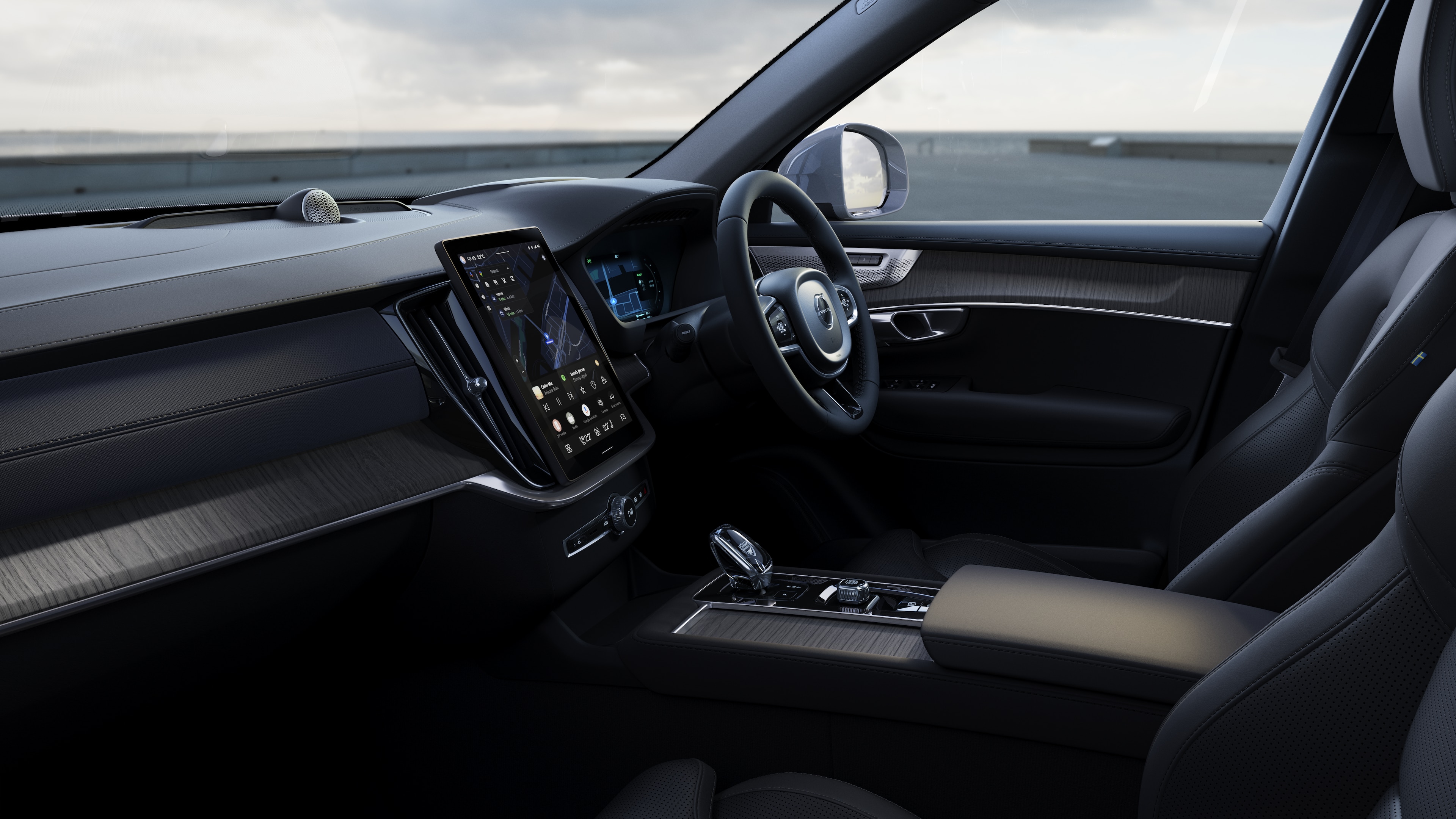 Volvo car interior showing dashboard, steering wheel, and center console with digital display in an open road background.