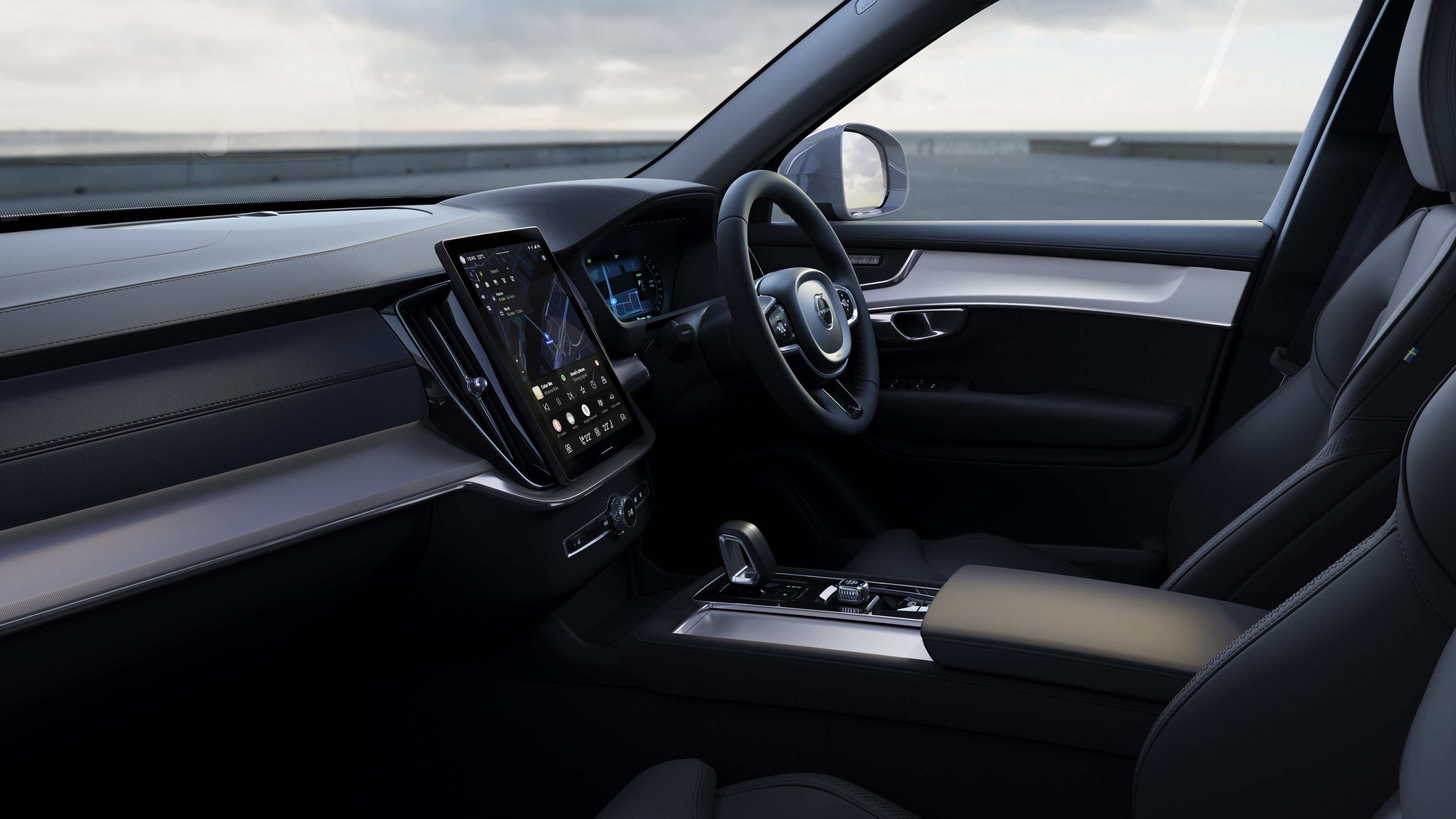 Volvo car interior showing dashboard, steering wheel, and center console with digital display in an open road background.