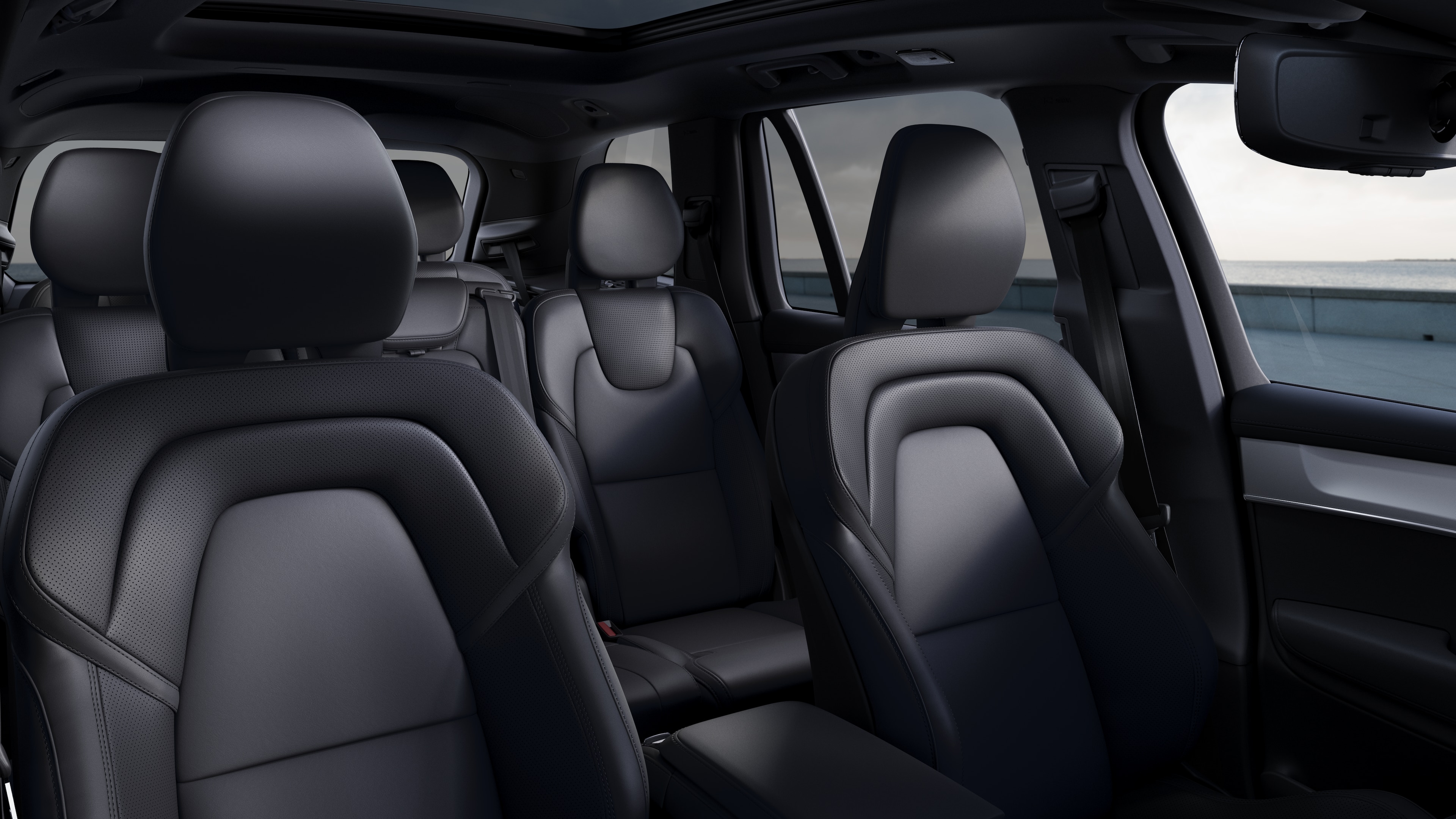 Volvo car interior showing front and rear passenger seats, steering wheel, dashboard, and center console against a plain studio background.