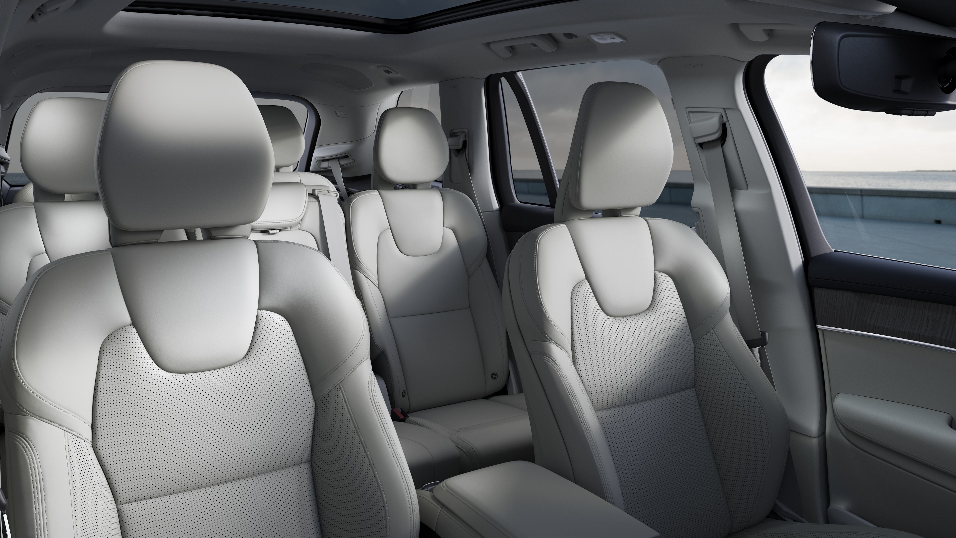 Volvo-interiör som visar passagerarsäten fram och bak, ratt, instrumentbräda och mittkonsol mot en enkel studiobakgrund.